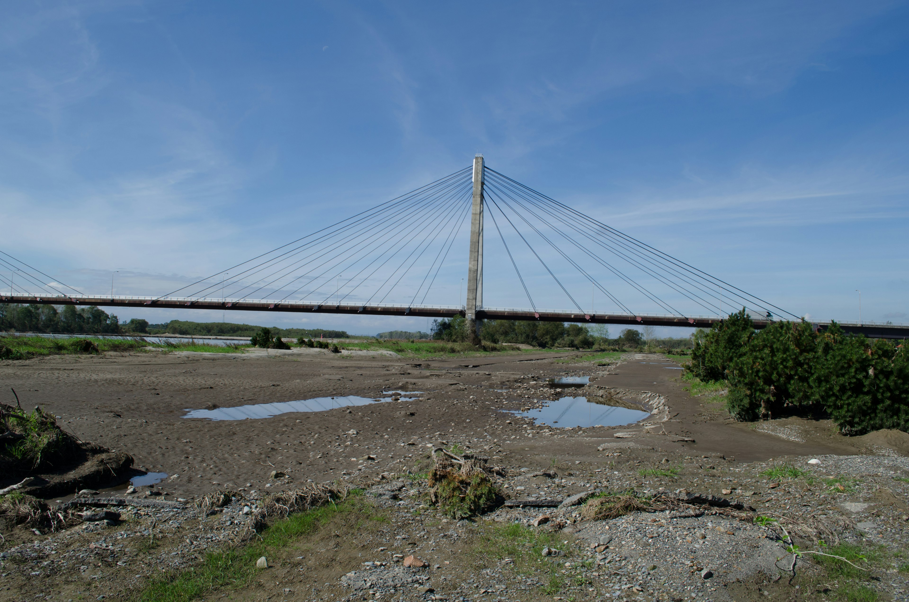 Landschaft mit blauem Himmel und Schrägseilbrücke Trockenes Flussbett unter der Brücke Sichtbar Umgeben von Steinen und Gras