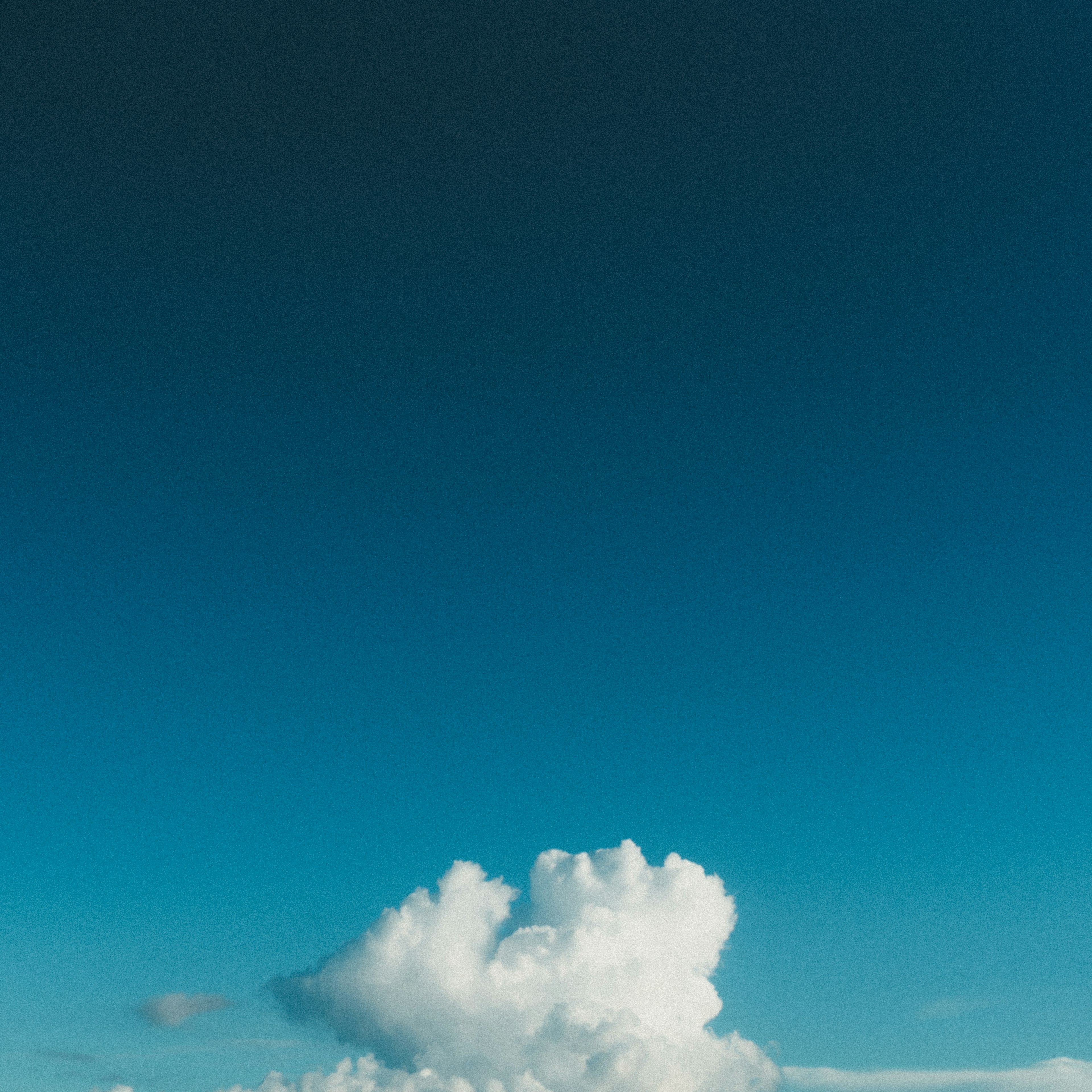 Eine Landschaft mit weißen Wolken, die in einem blauen Himmel schweben