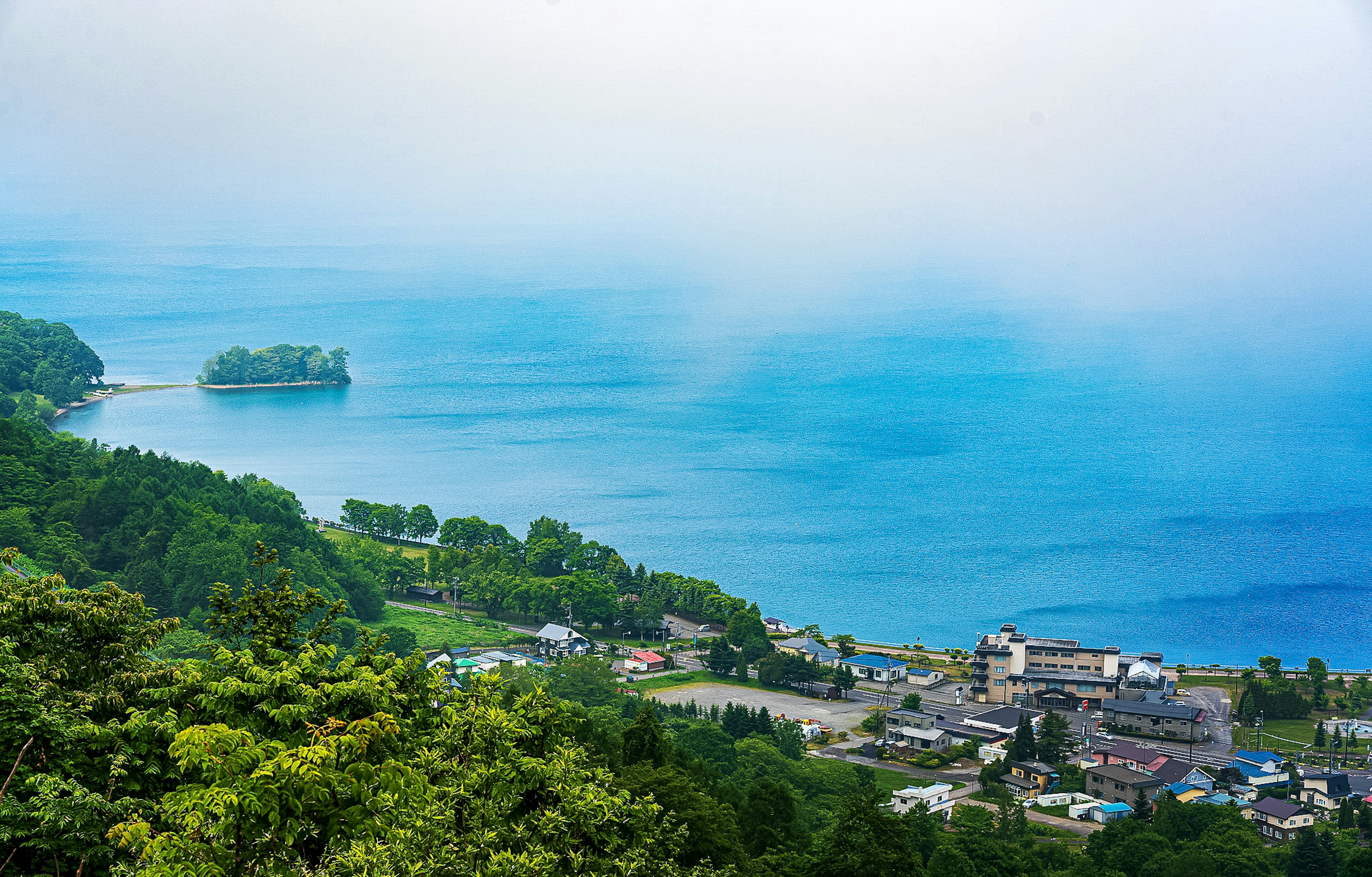 青い海と緑の山々に囲まれた小さな町の風景