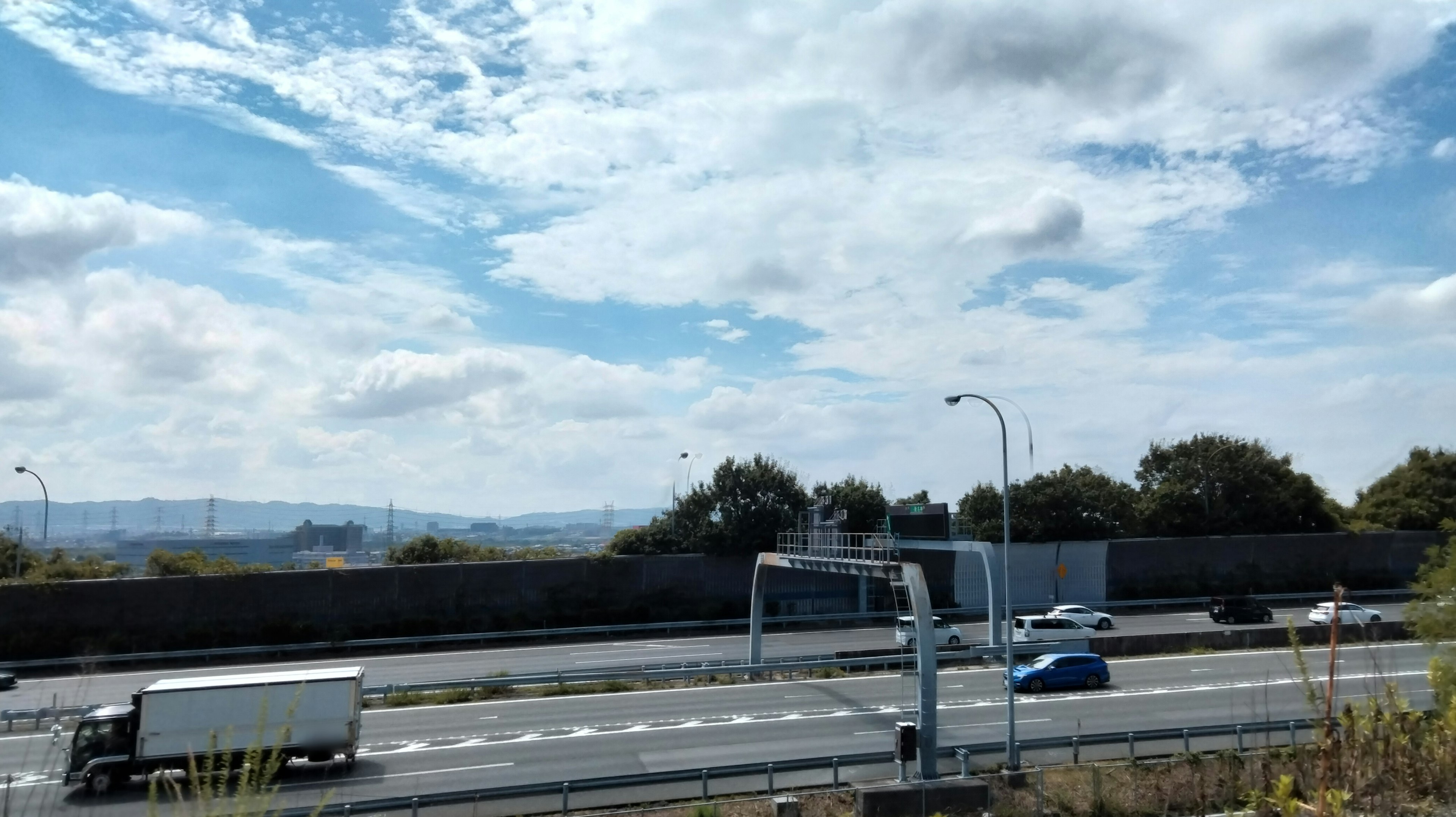 Pemandangan indah dengan langit biru dan awan jalan raya terlihat kendaraan bergerak