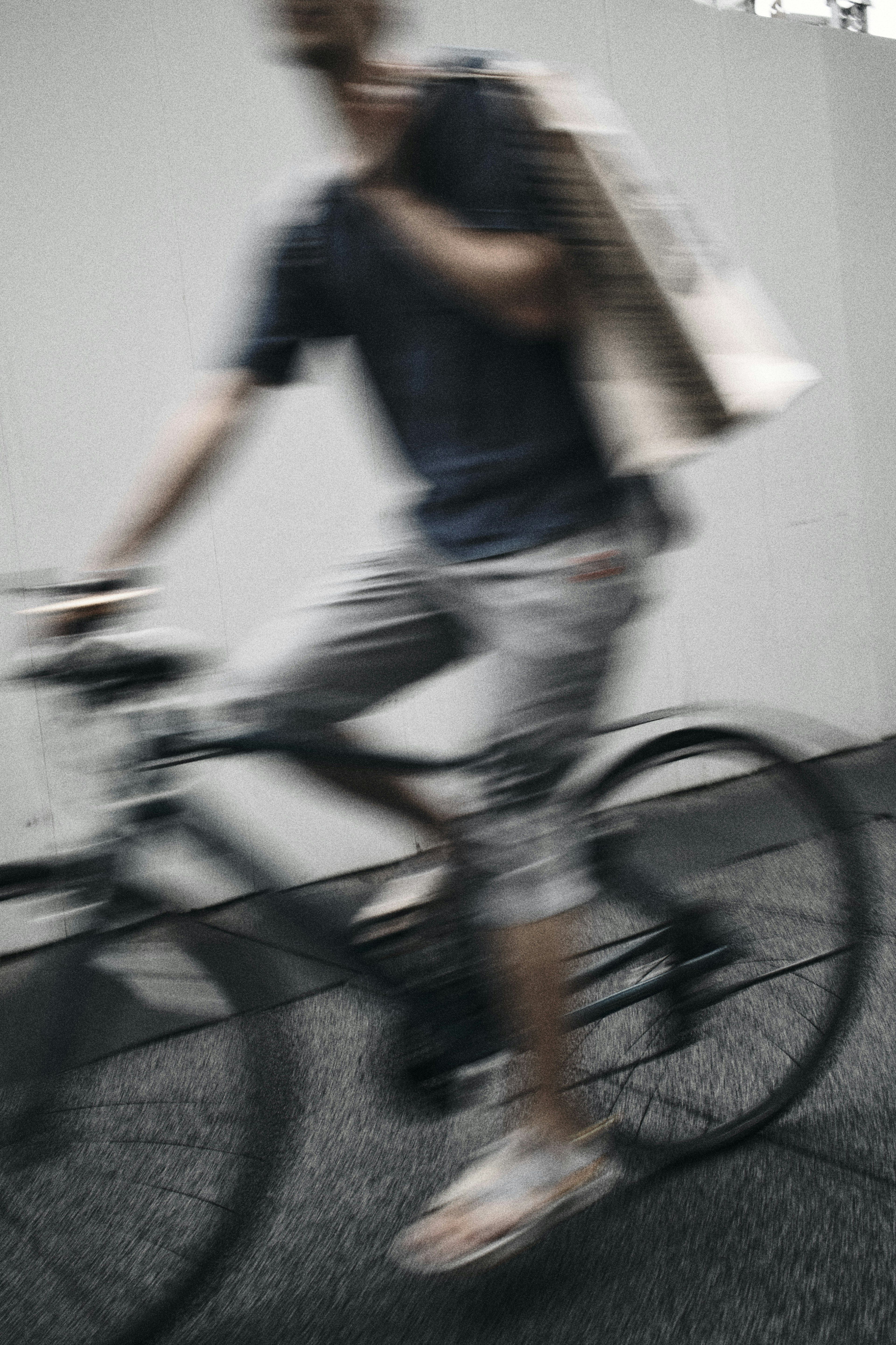 Hombre montando en bicicleta en movimiento borroso sosteniendo una bolsa