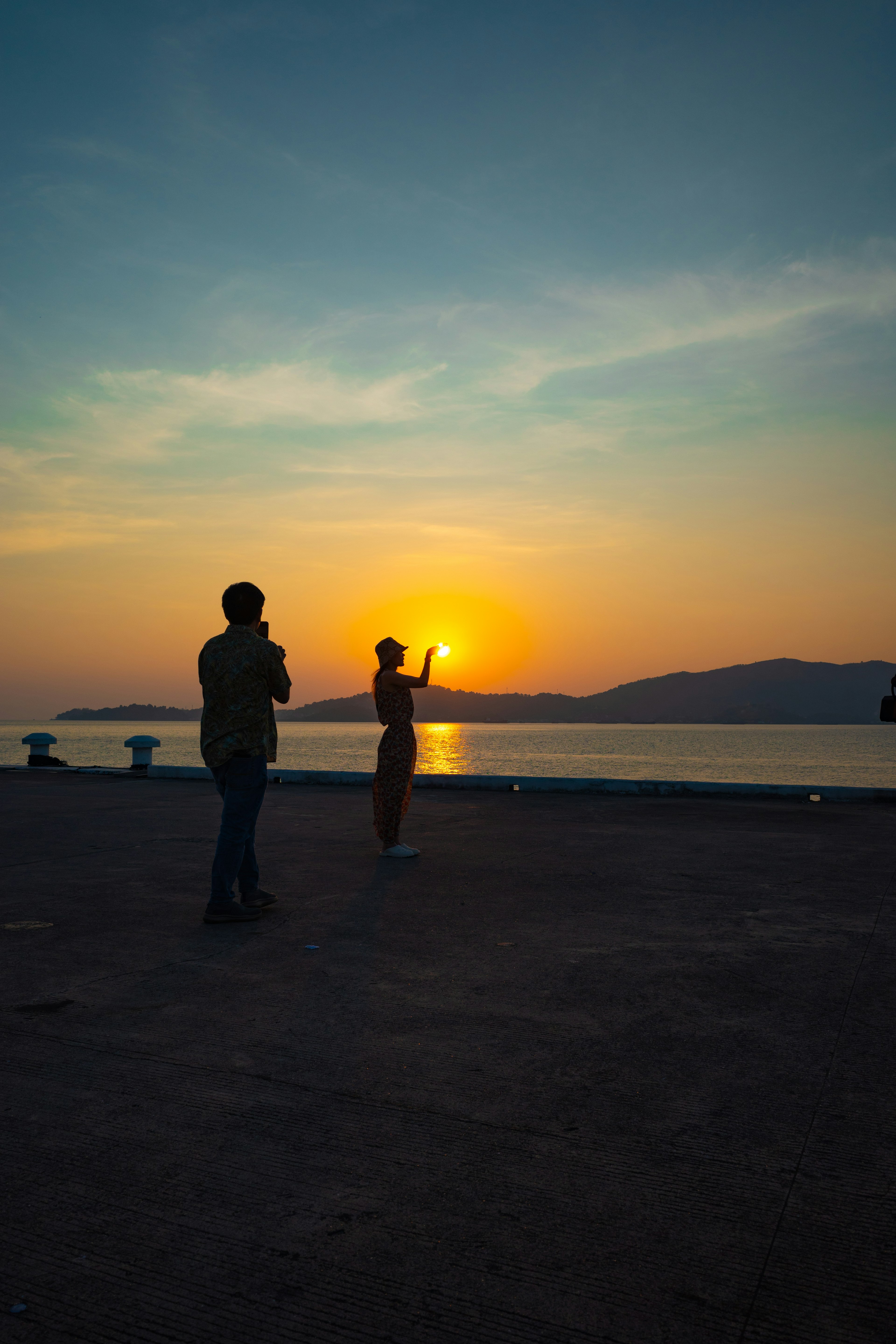 夕日を背景に立つ二人のシルエット