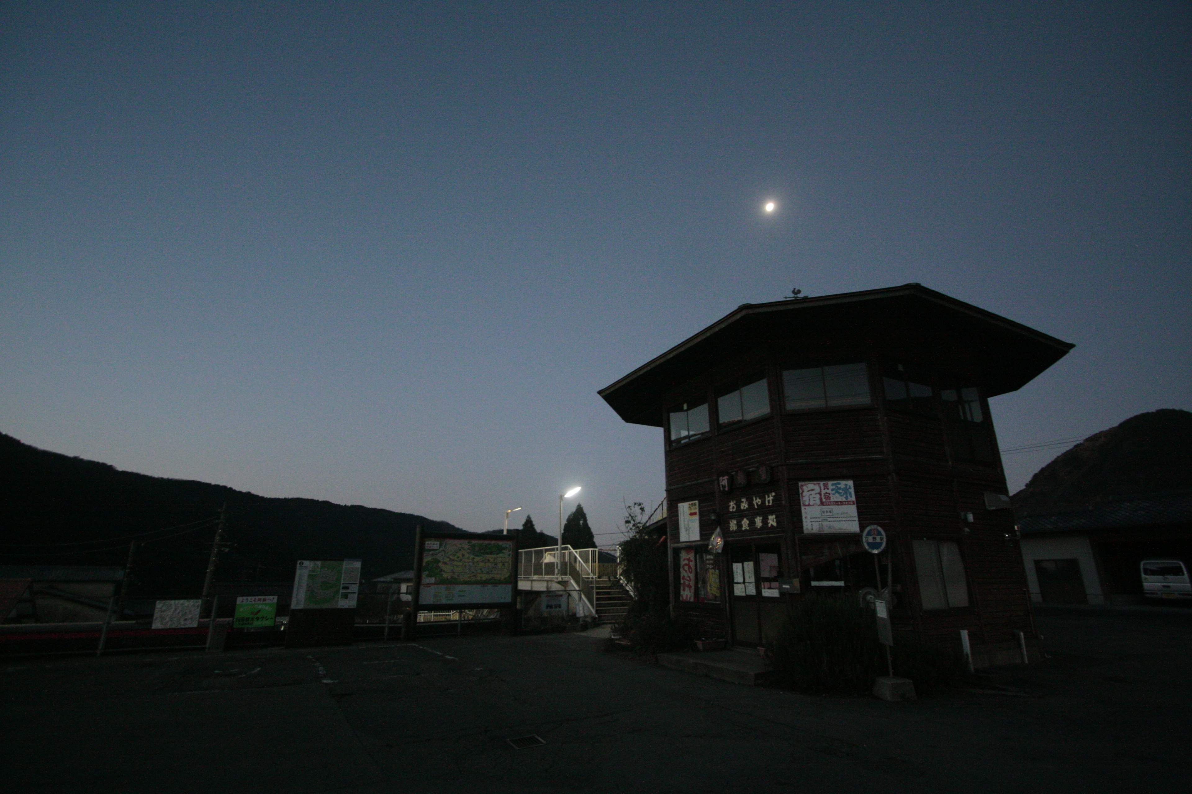 夕暮れ時の建物と月の風景