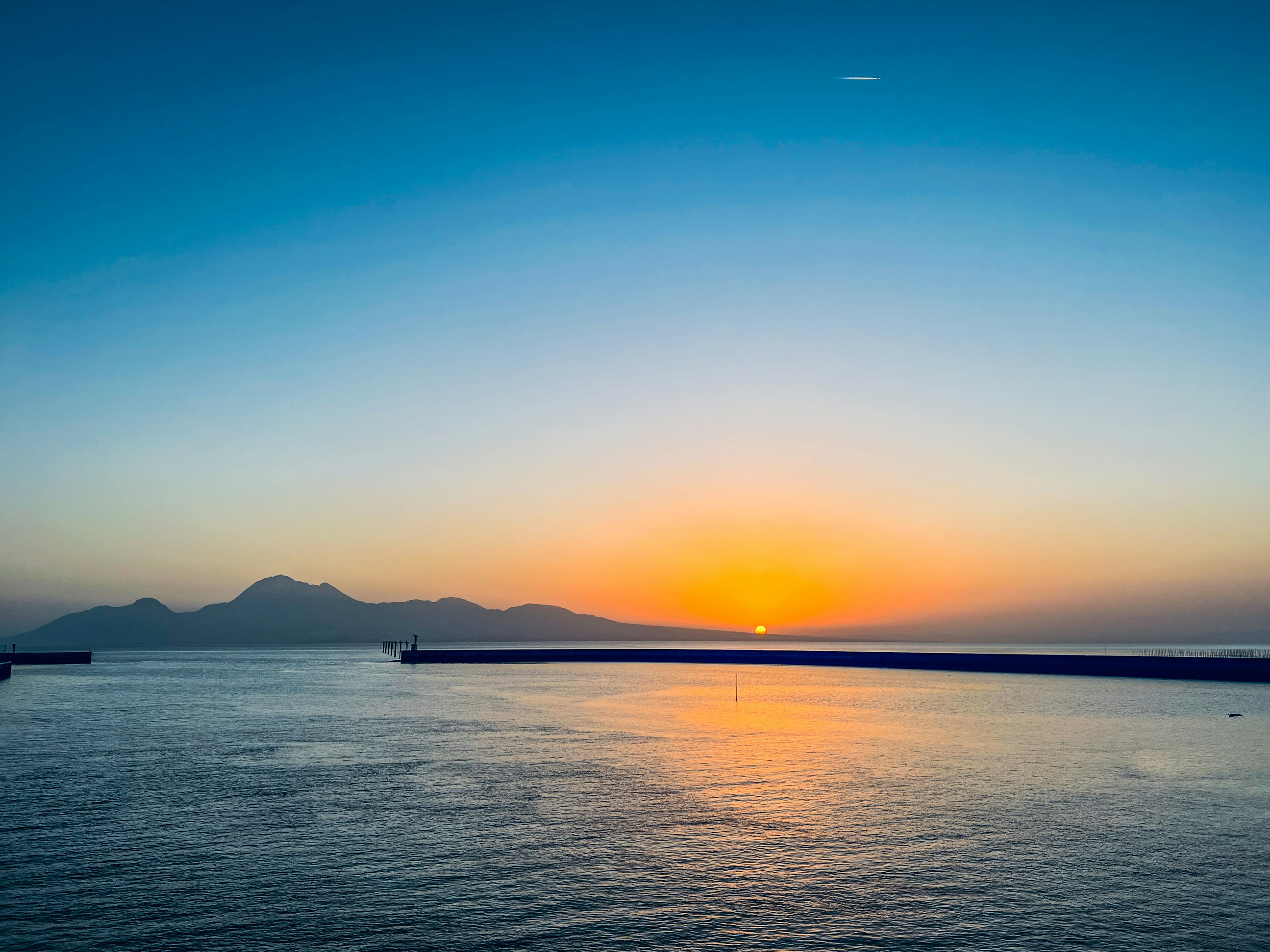 Bellissimo tramonto sul mare con montagne sullo sfondo