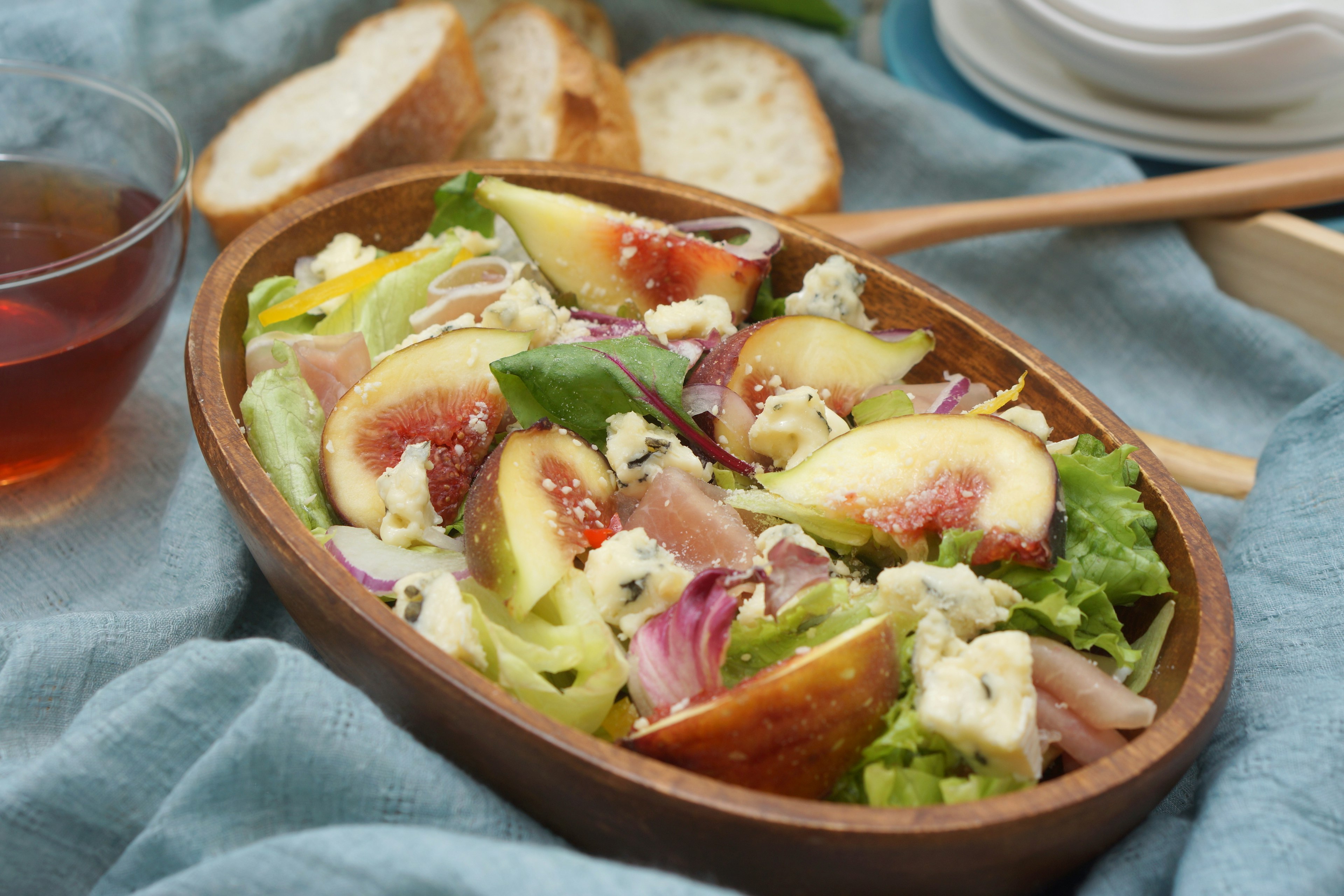 Salade fraîche avec des figues et du fromage bleu dans un bol en bois