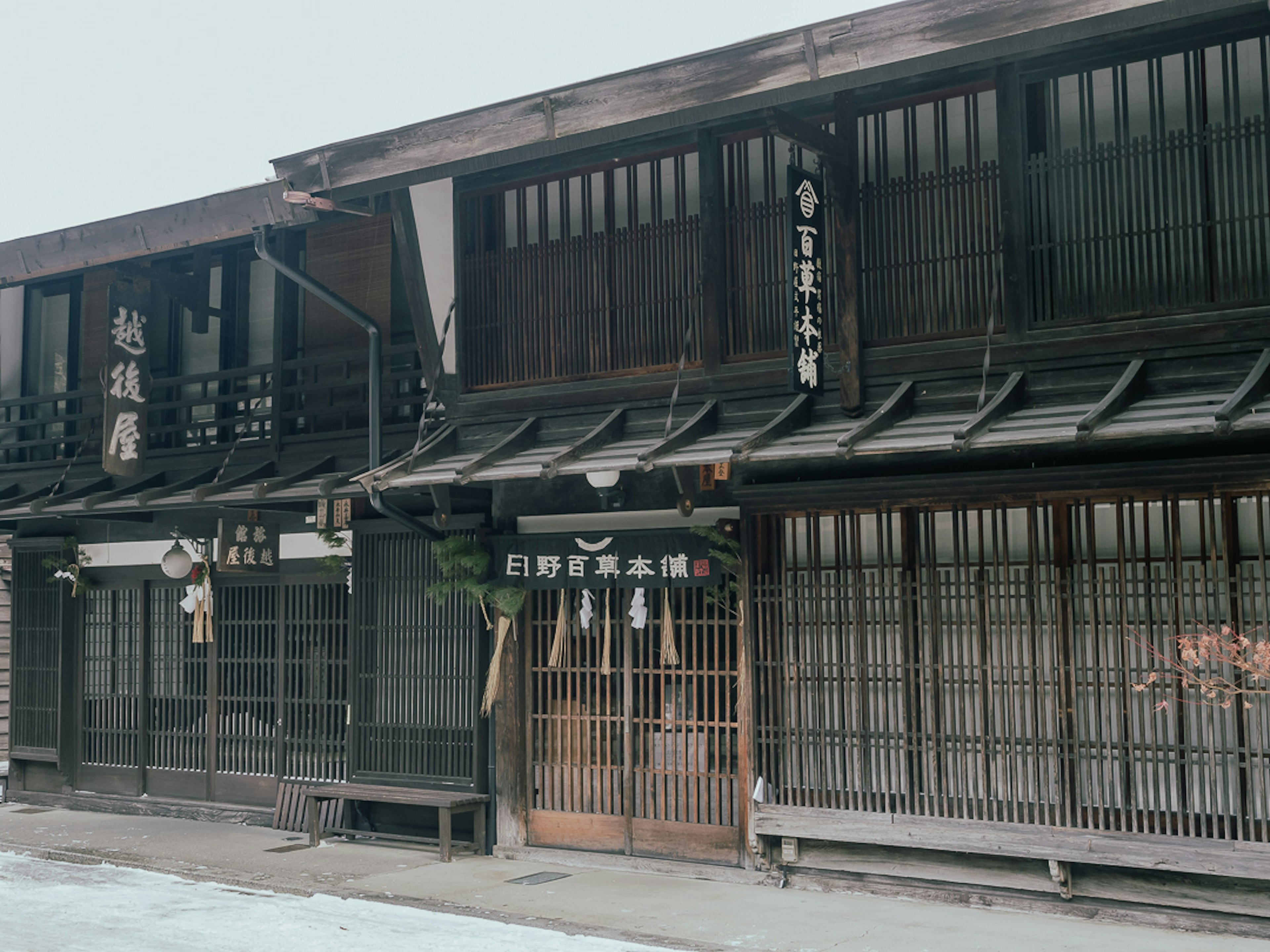 Extérieur d'un bâtiment japonais traditionnel avec une structure en bois et des enseignes japonaises