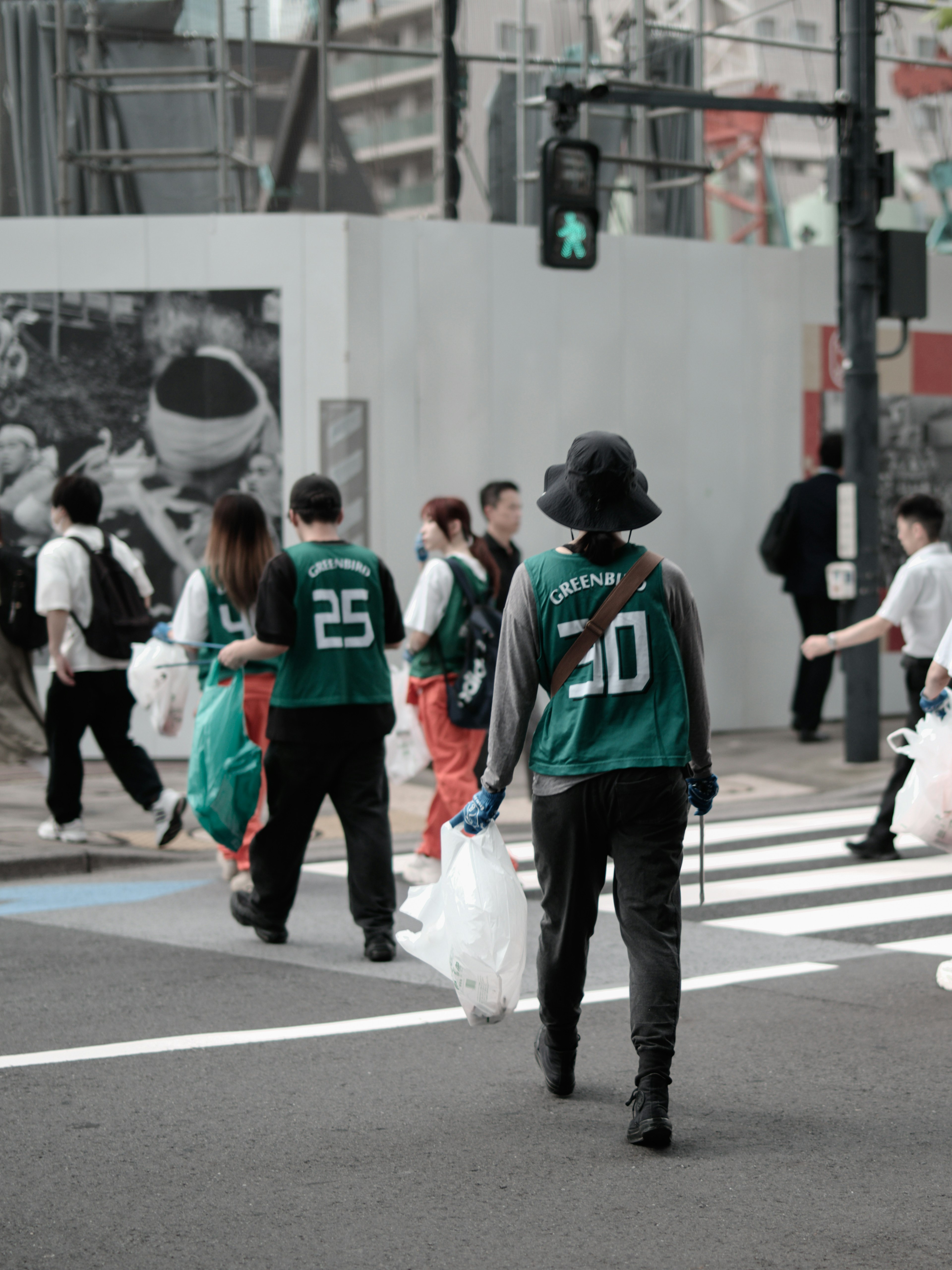 Groupe de personnes traversant la rue avec des sacs