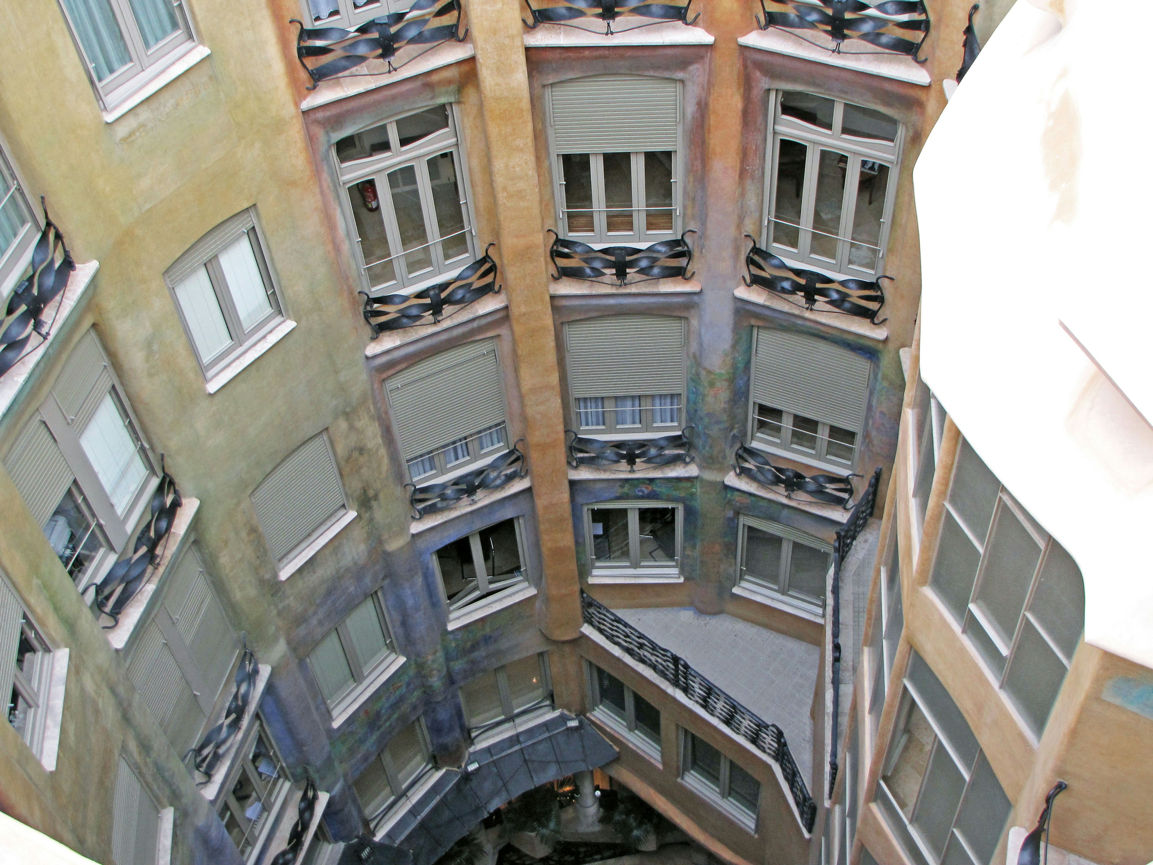 Vista del cortile interno della Casa Mila con muri e finestre colorate