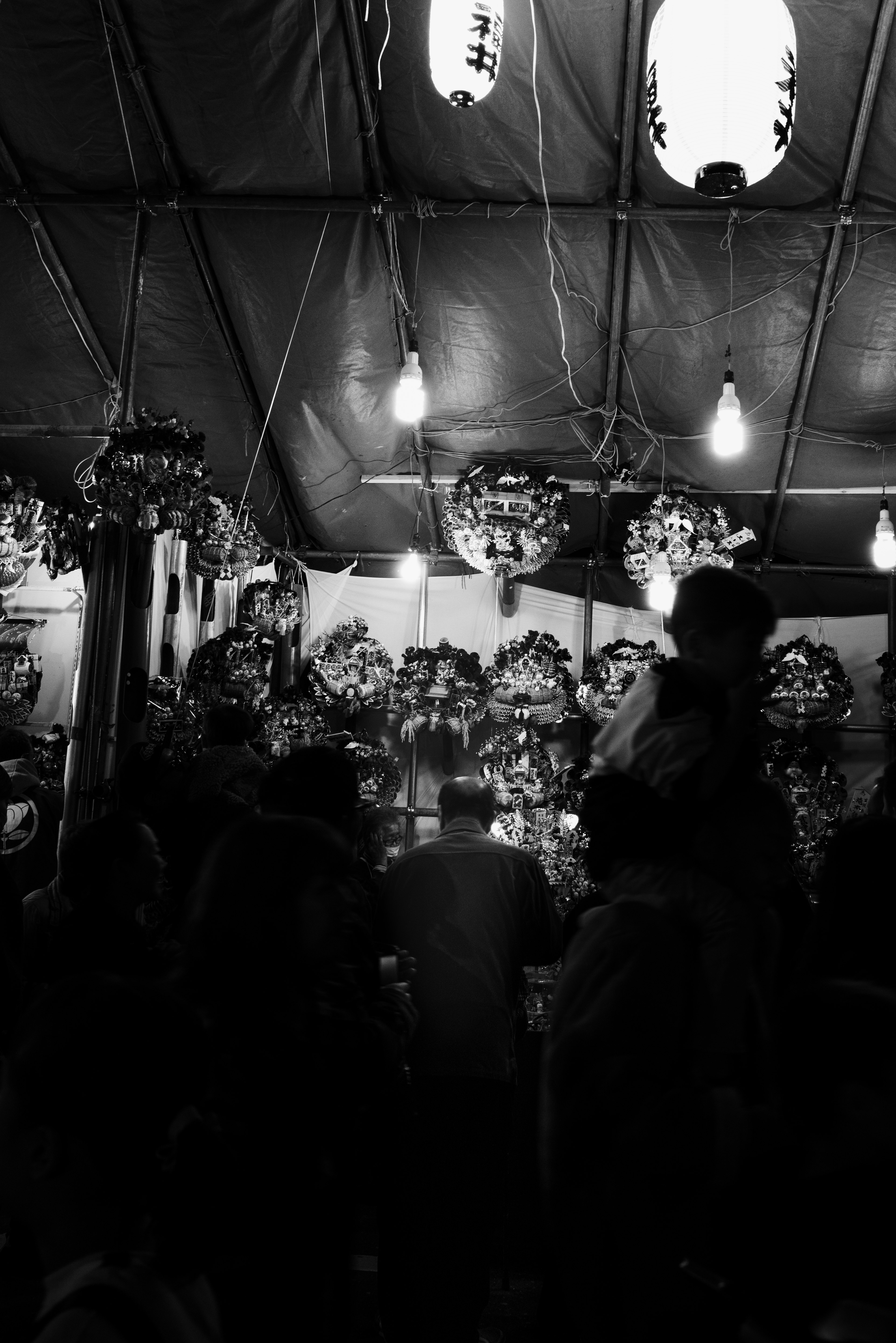 Dimly lit scene with floral decorations and silhouettes of people