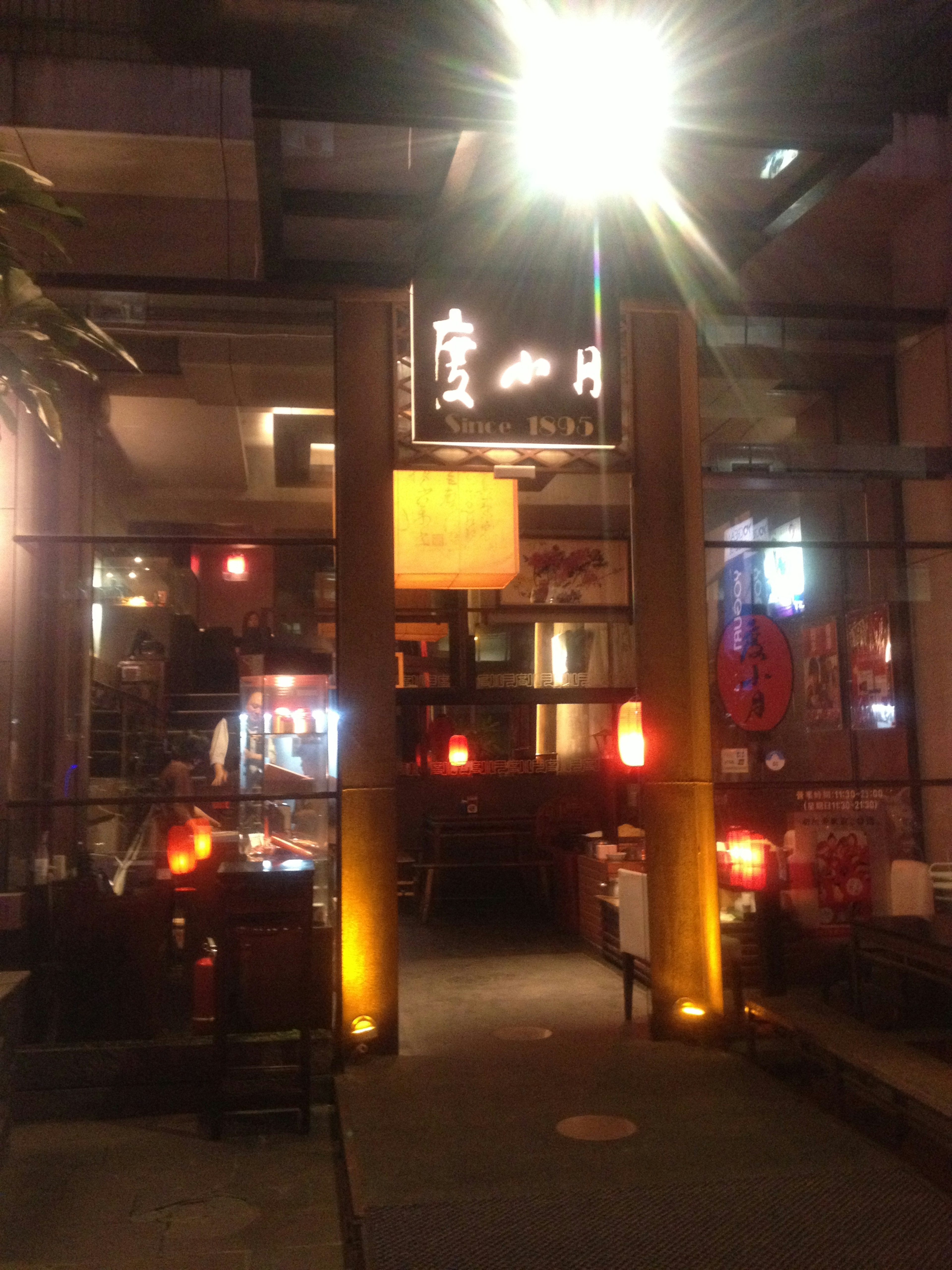 Entrance of a restaurant with bright signage and warm lighting