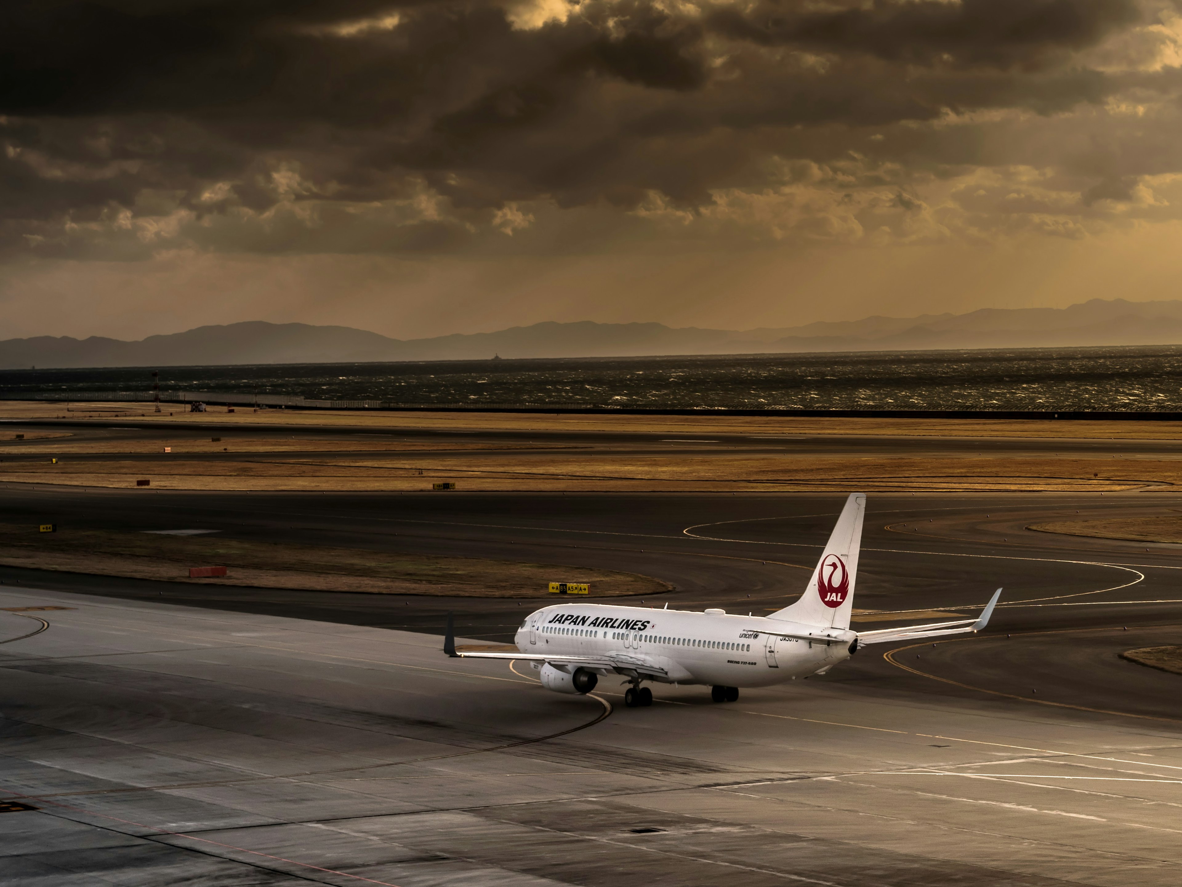 Airplane taxiing at the airport under dark clouds