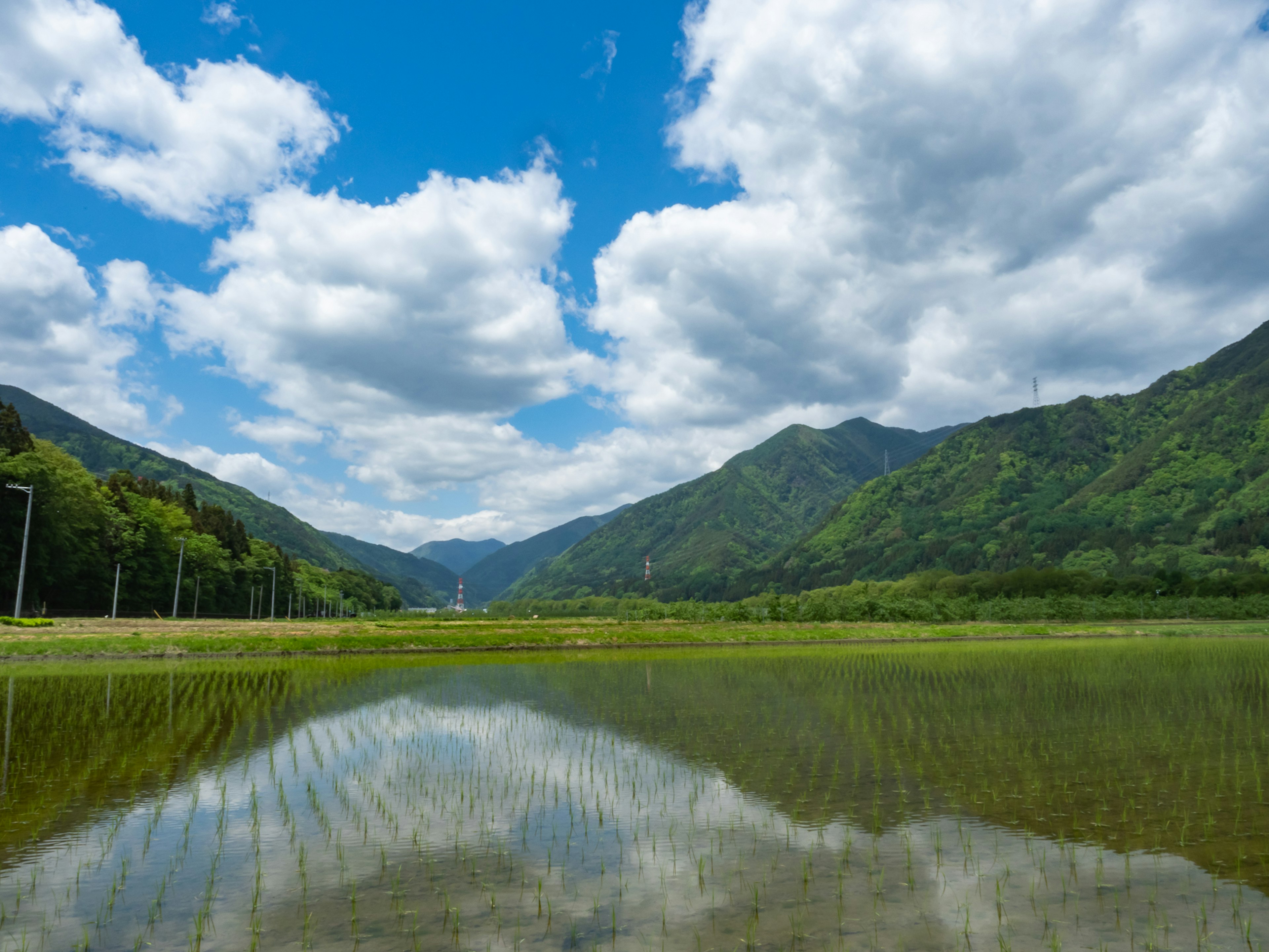 Paysage montagneux magnifique avec un ciel bleu et des nuages blancs se reflétant sur l'eau calme