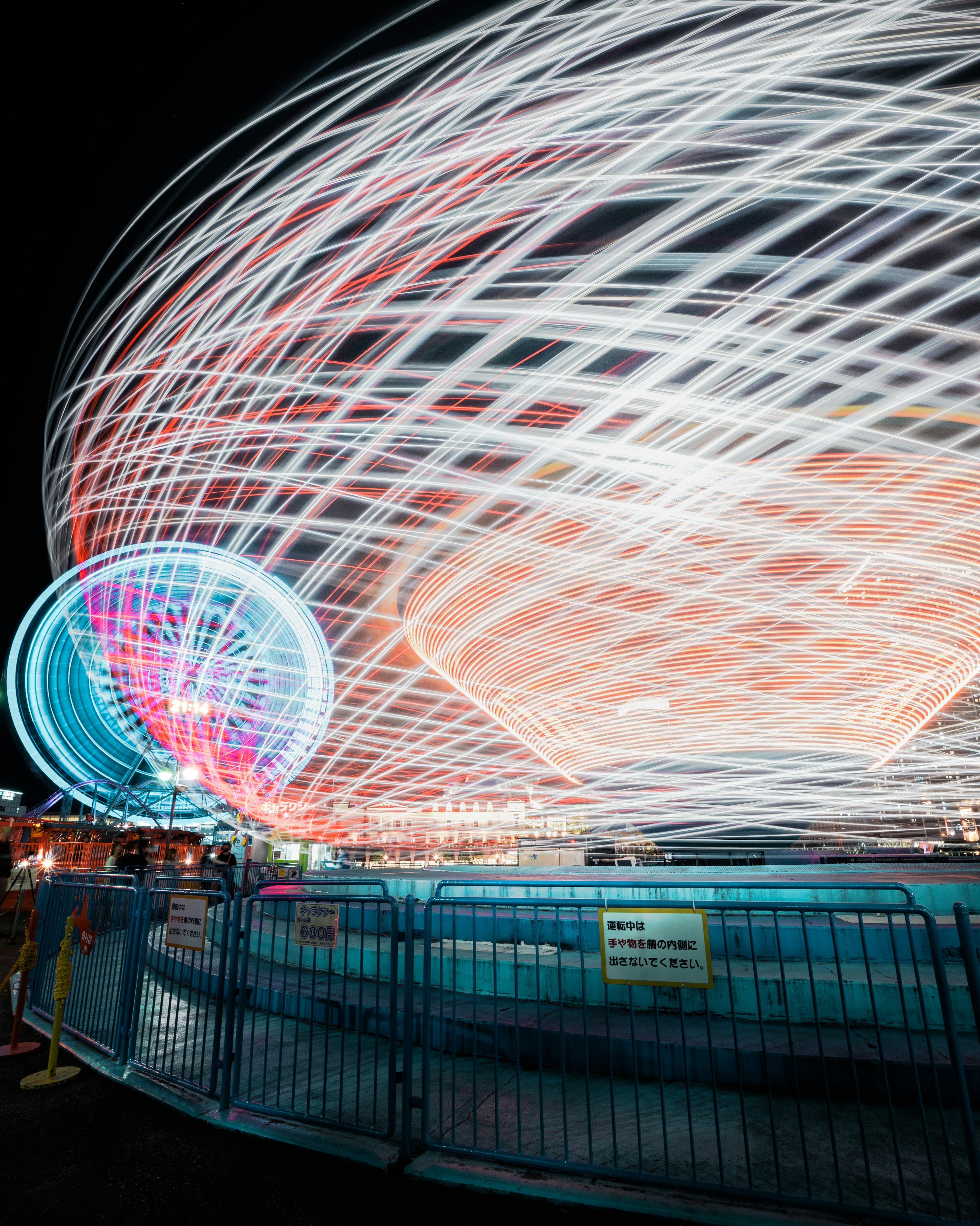 Luces vibrantes de una atracción giratoria y de la noria por la noche