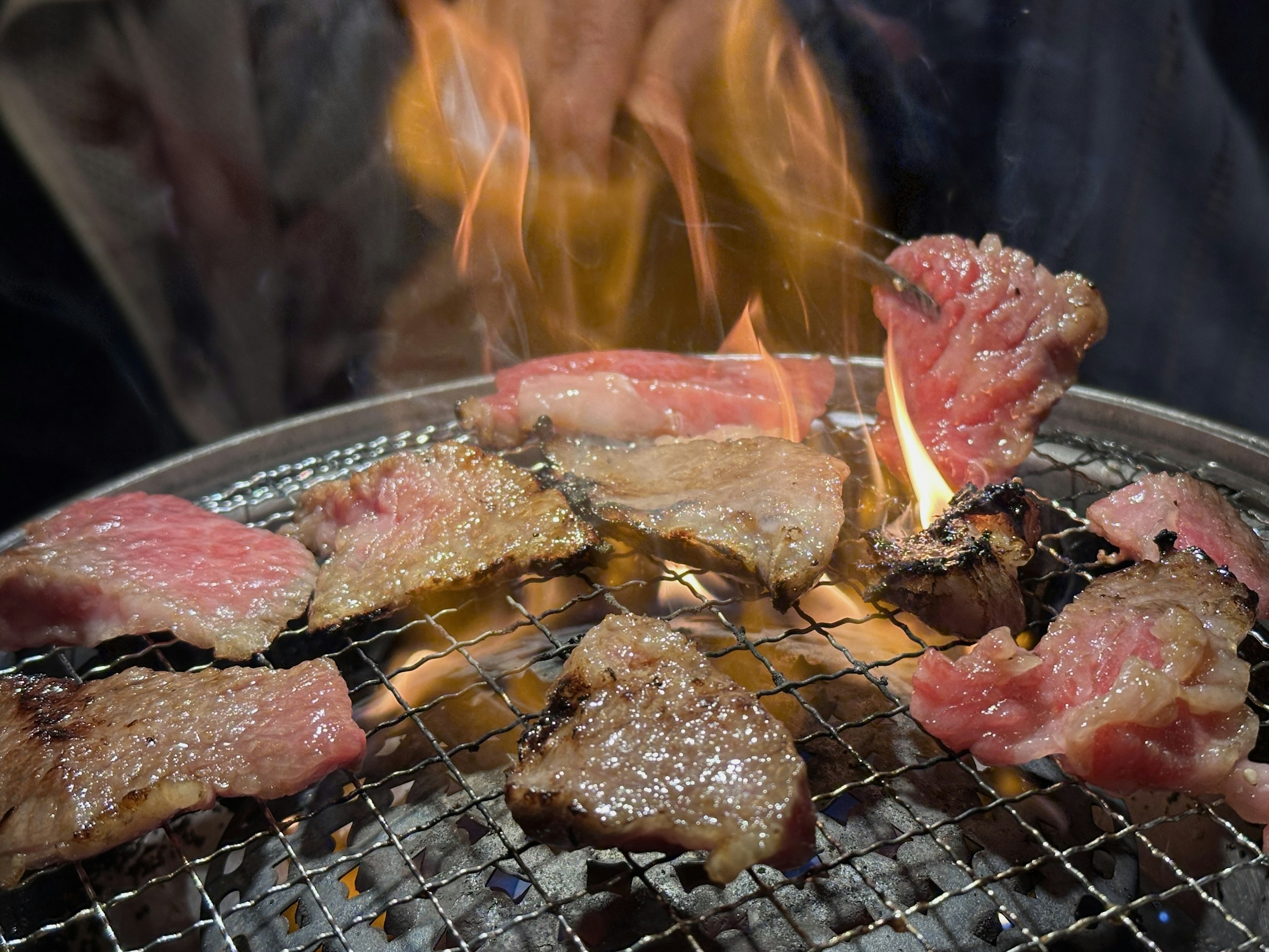 Fleischstücke auf dem Grill mit Flammen