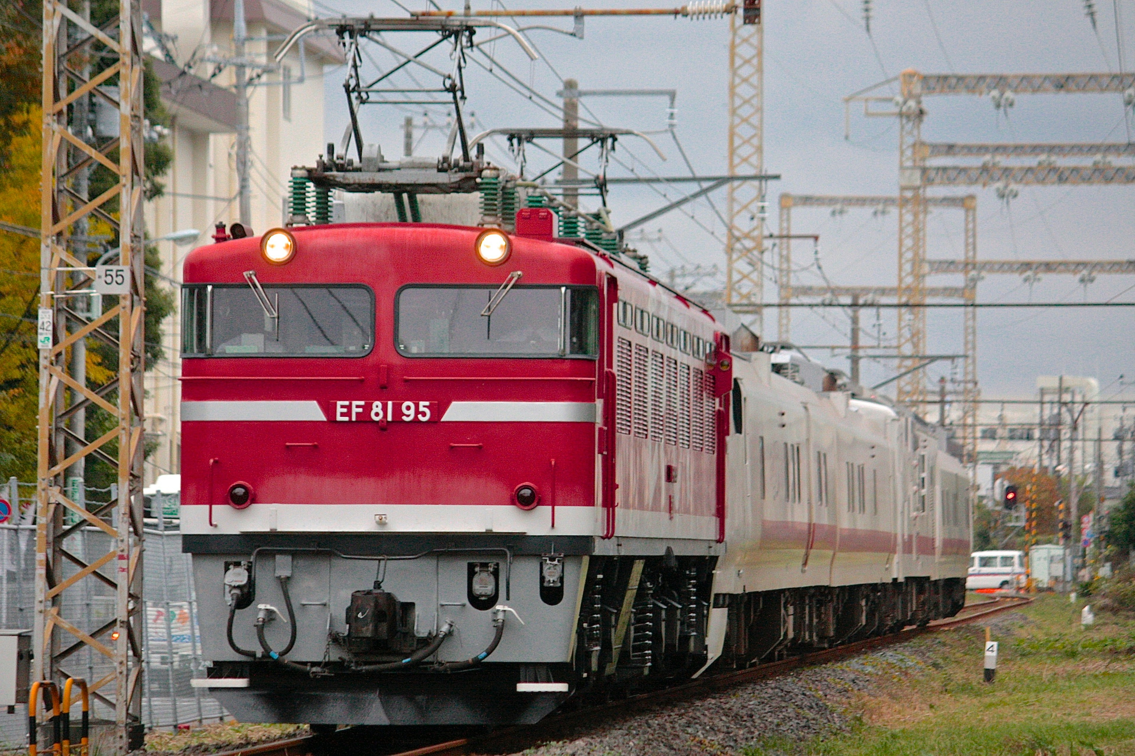 赤い電車が線路を走る風景 電車の番号はEF81 95