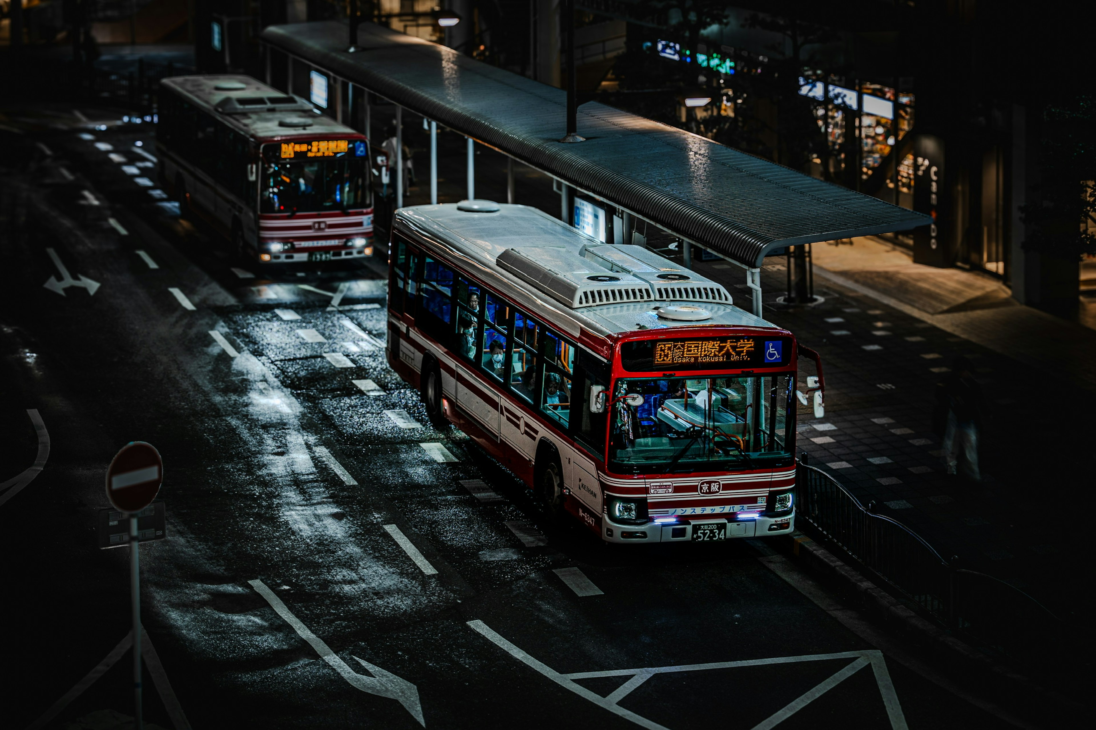 Strada cittadina di notte con un autobus e una fermata dell'autobus