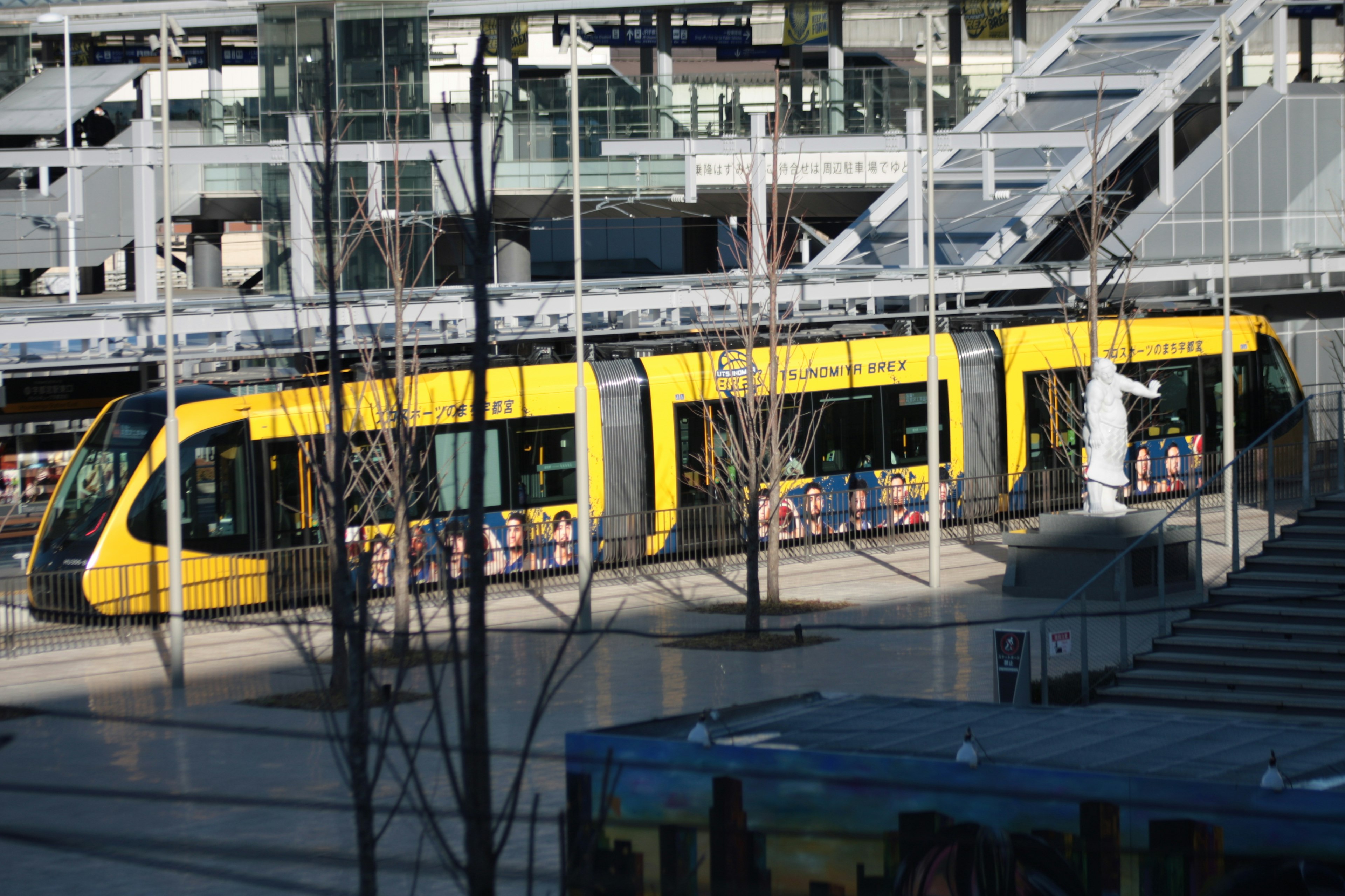 A yellow tram parked at a station platform