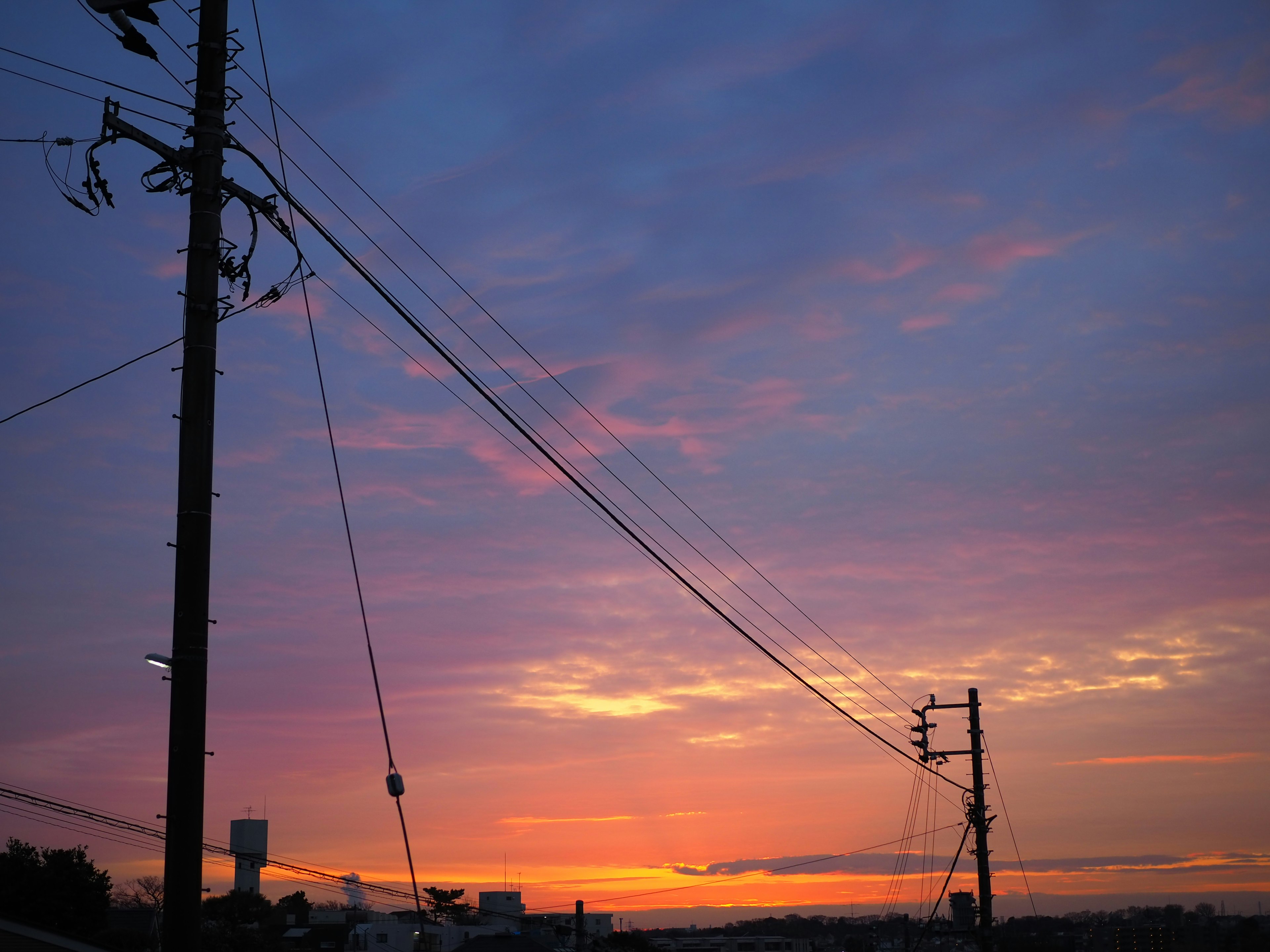 美しい夕焼け空に電柱と電線が映える風景