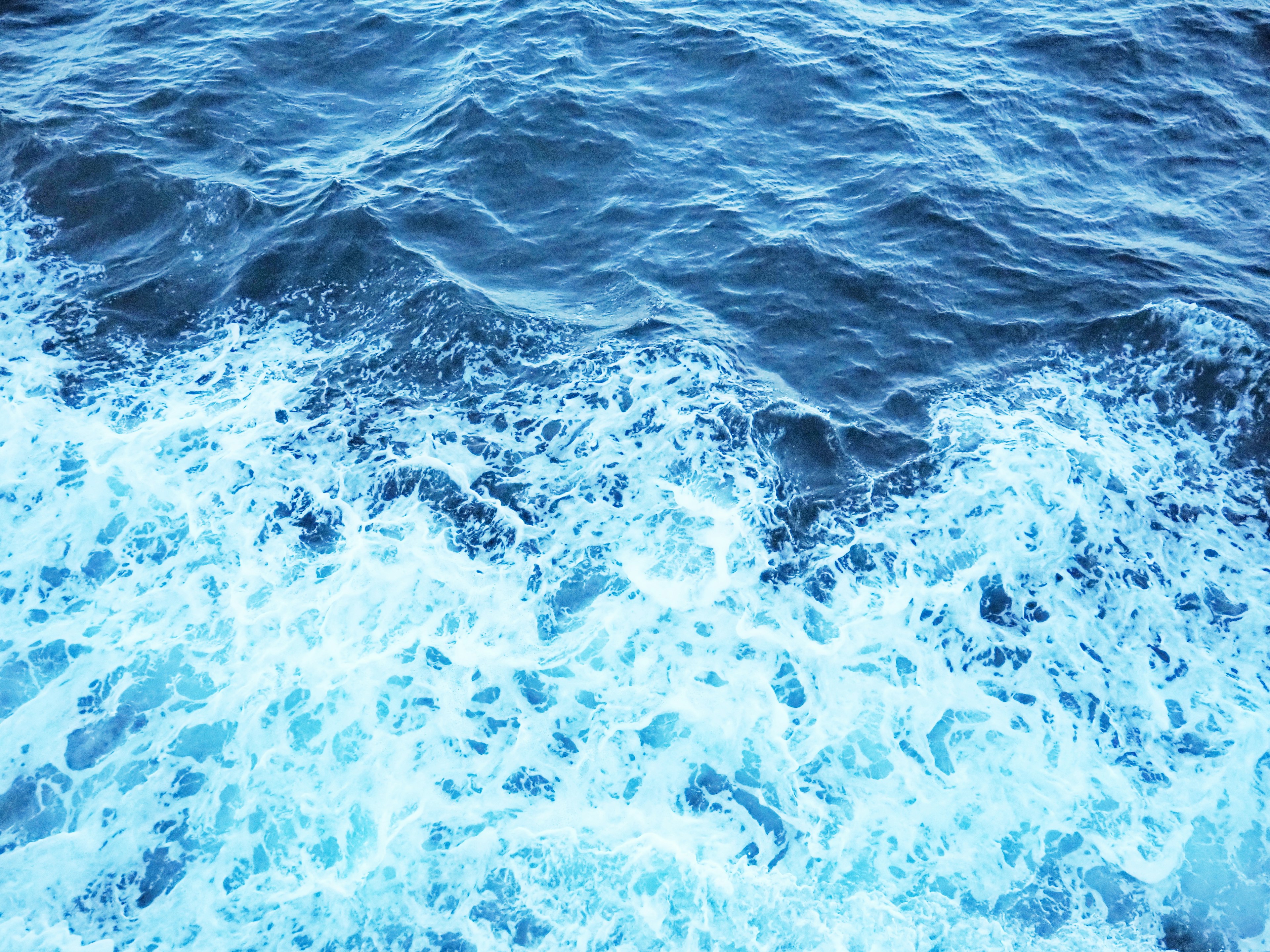 Textured blue ocean waves with foam