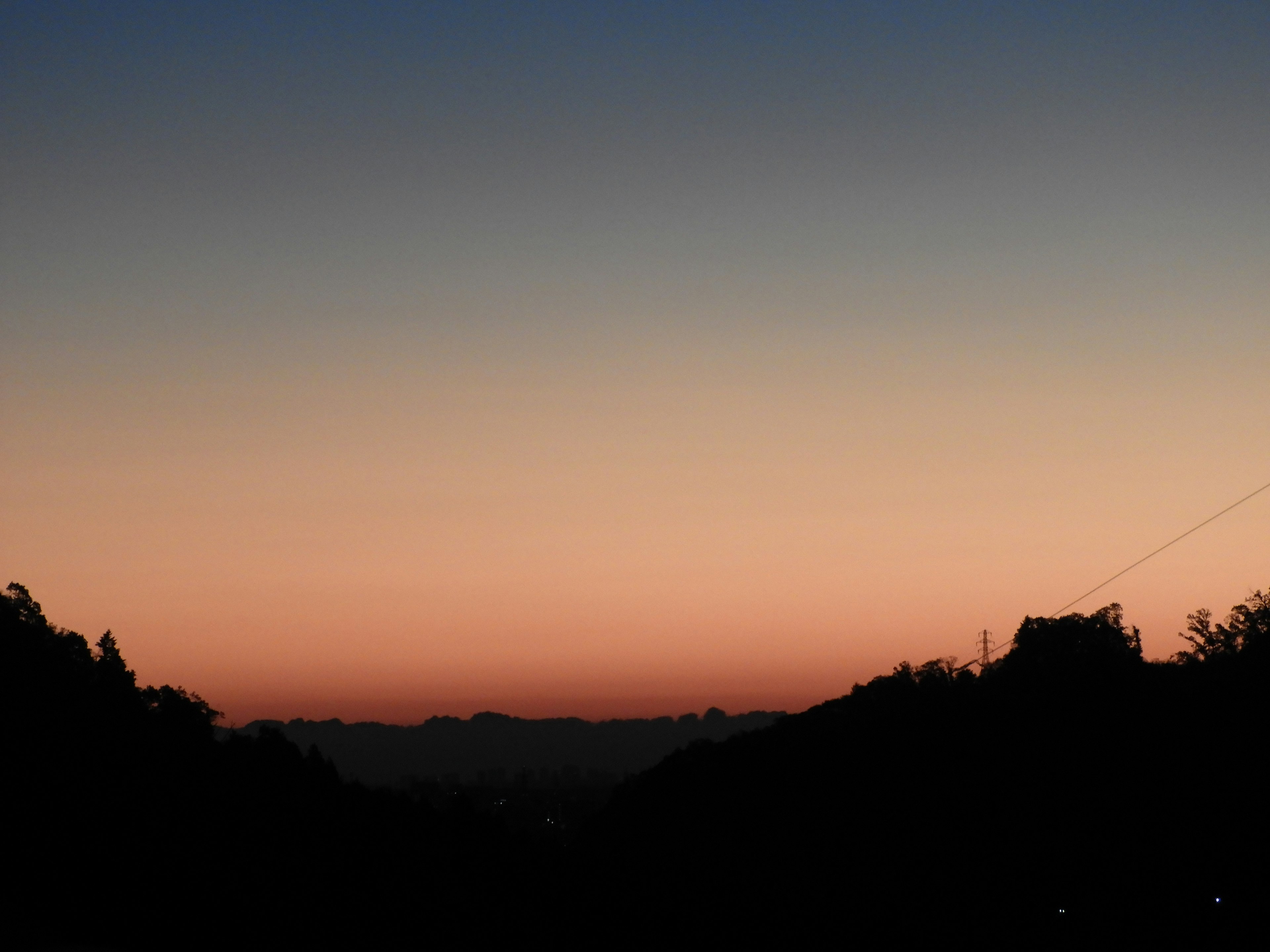 Ruhige Sonnenuntergangslandschaft mit orange-blauem Farbverlauf Bergsilhouette