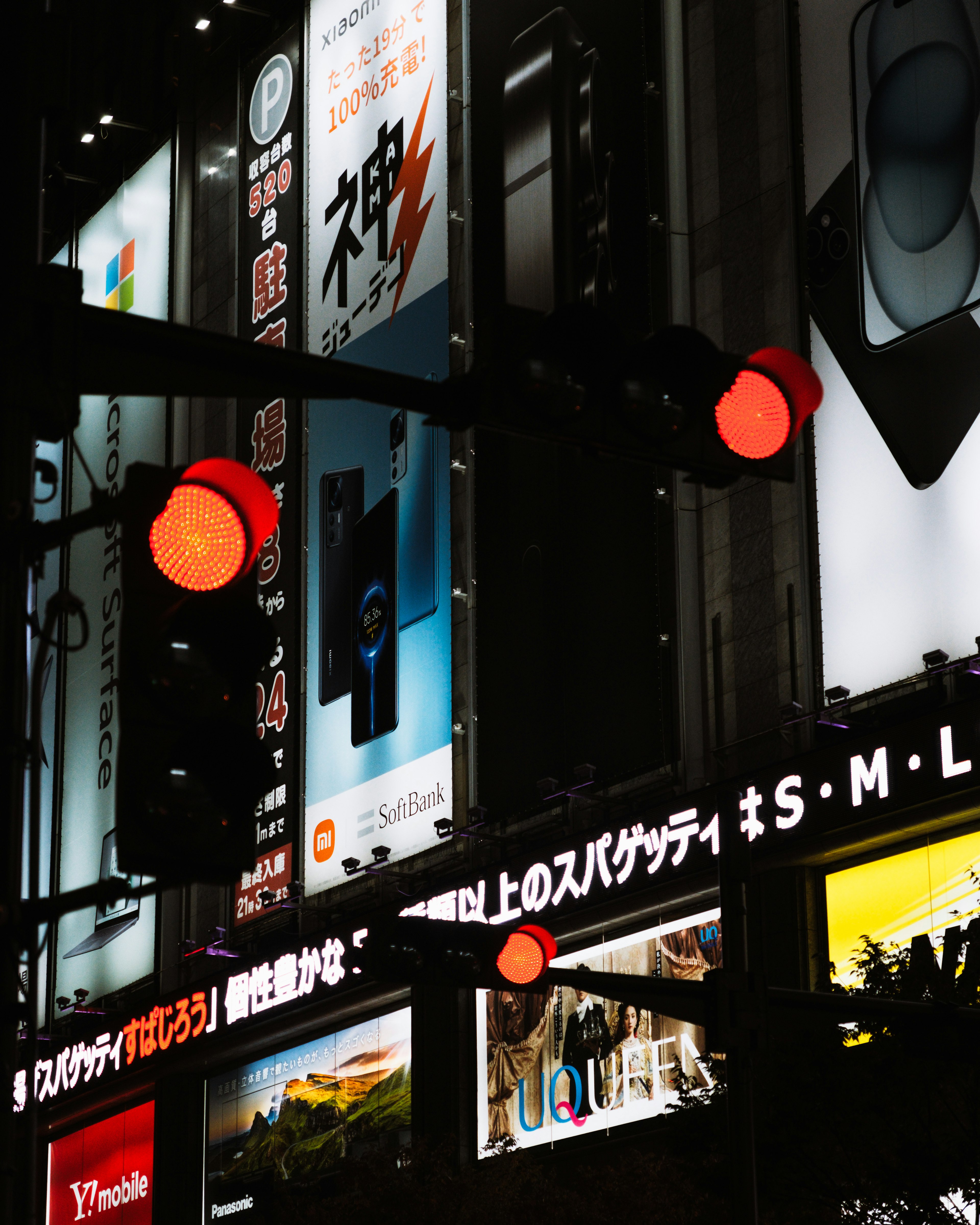 Scène nocturne avec des feux rouges et diverses publicités et enseignes