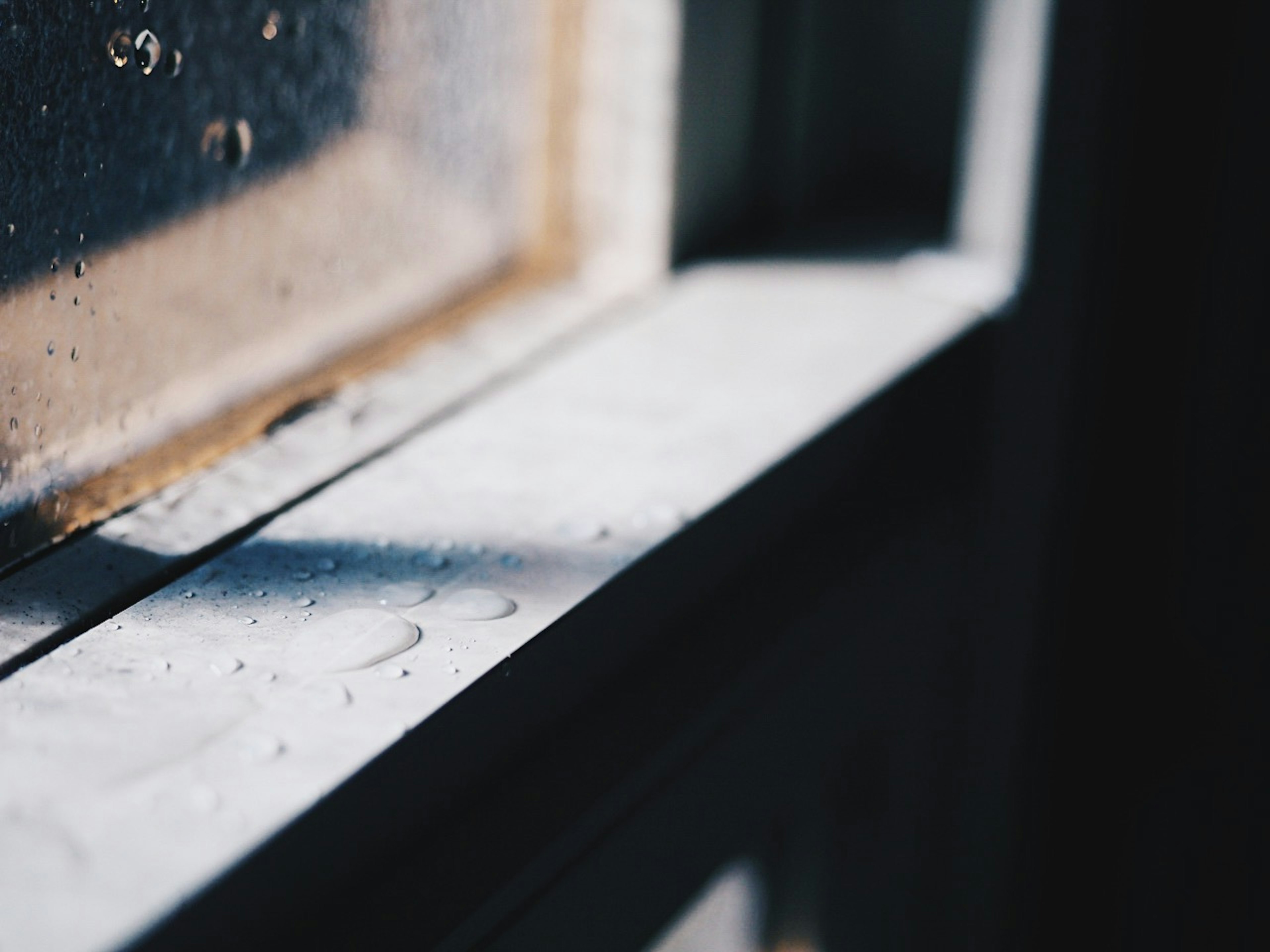 Nahaufnahme einer Fensterbank mit Wassertropfen