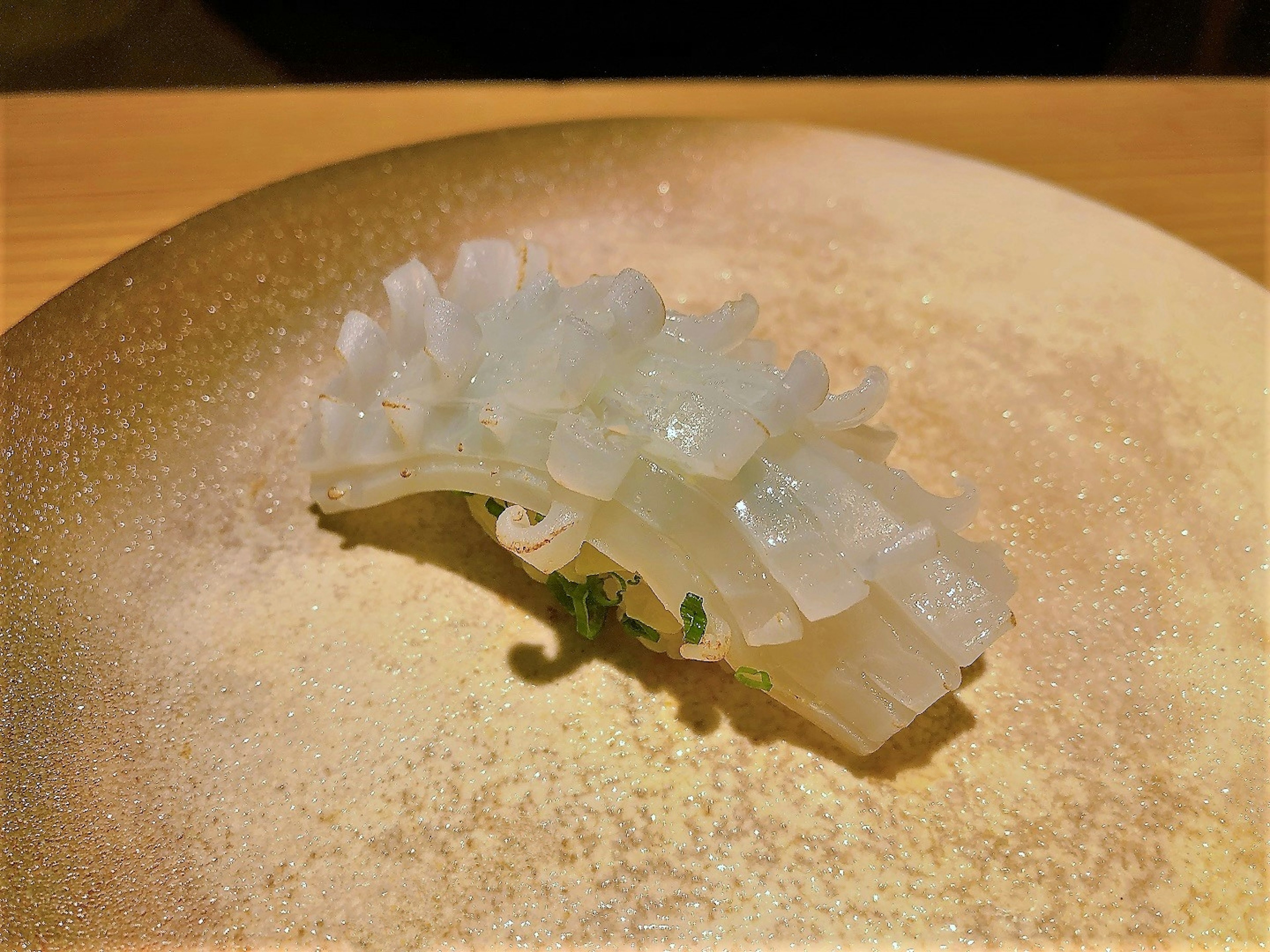 Delicately arranged translucent seafood on a plate