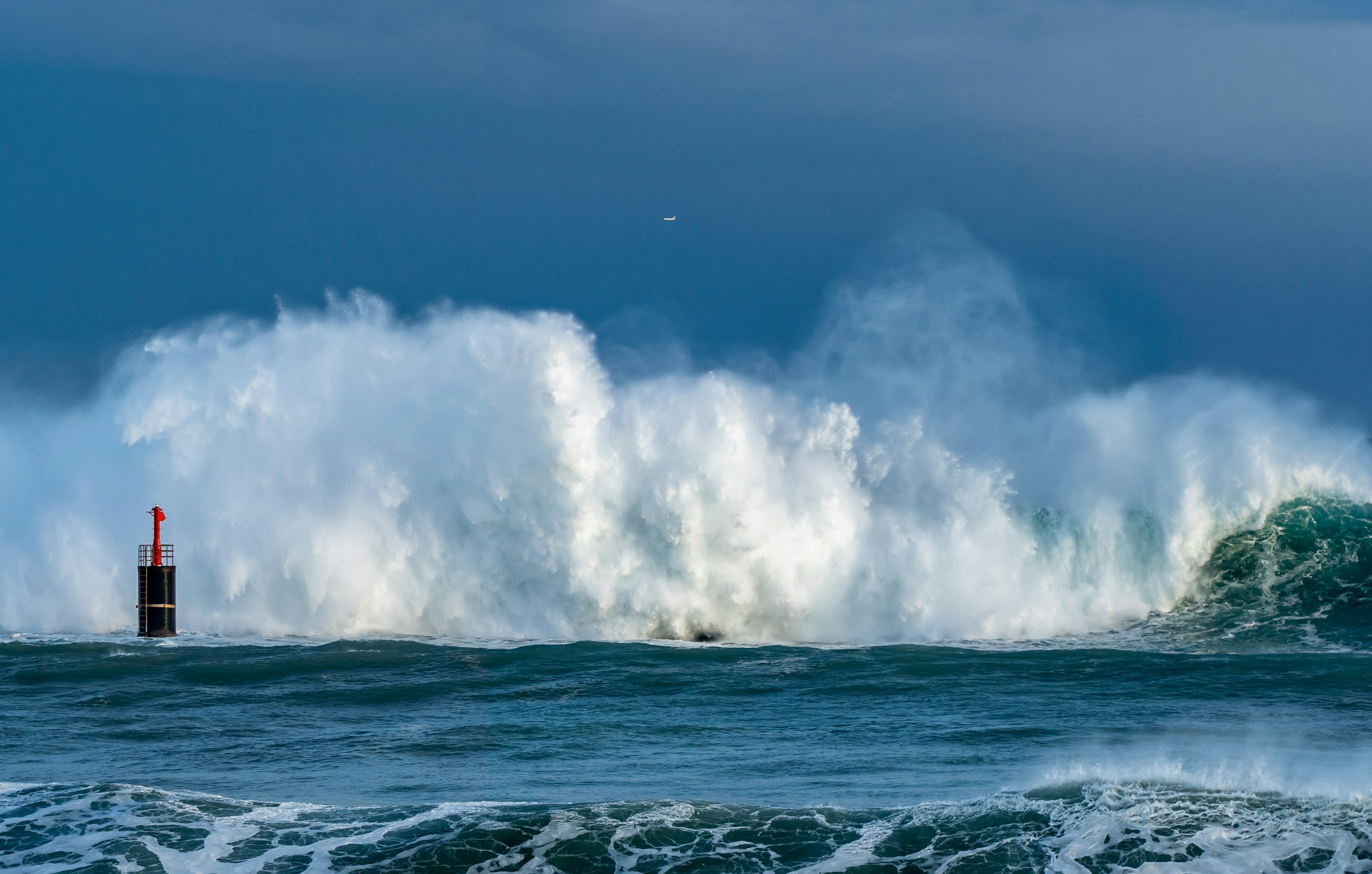 Onde tempestose che si infrangono vicino a una boa rossa nell'oceano