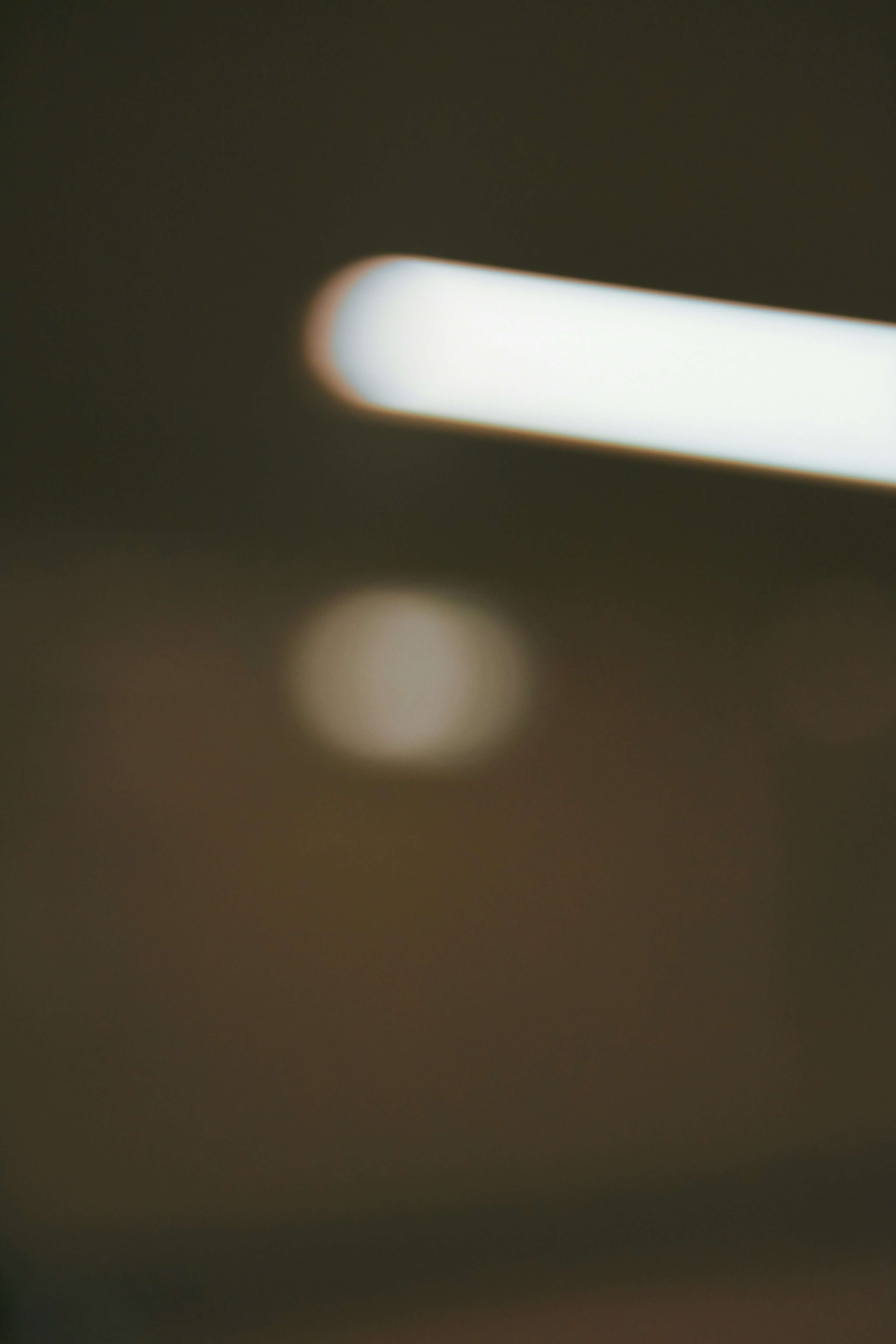 Blurred background with bright fluorescent light and indistinct circular light spot