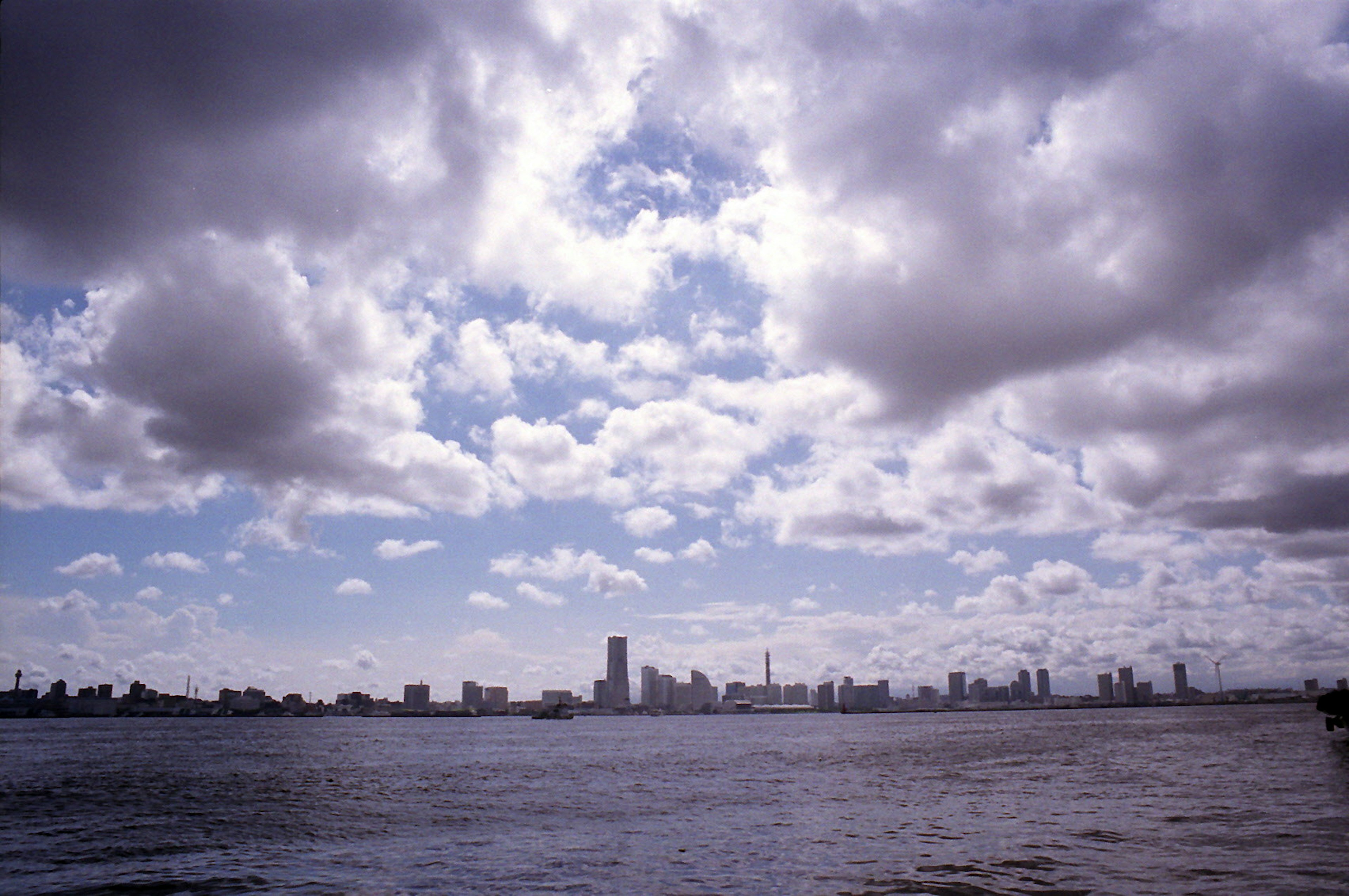 City skyline over water with dramatic clouds