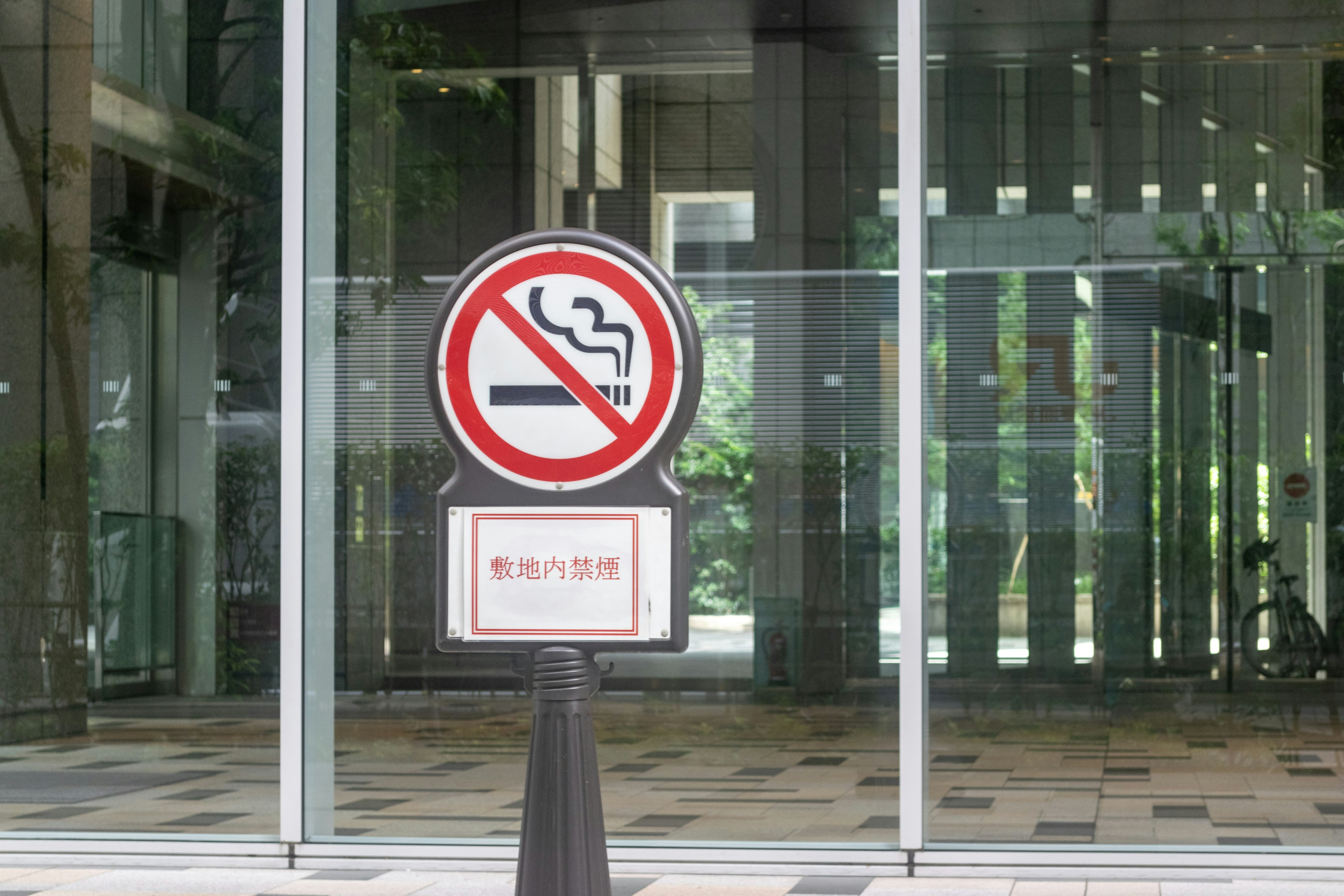 Señal de prohibición de fumar con un mensaje de advertencia en japonés