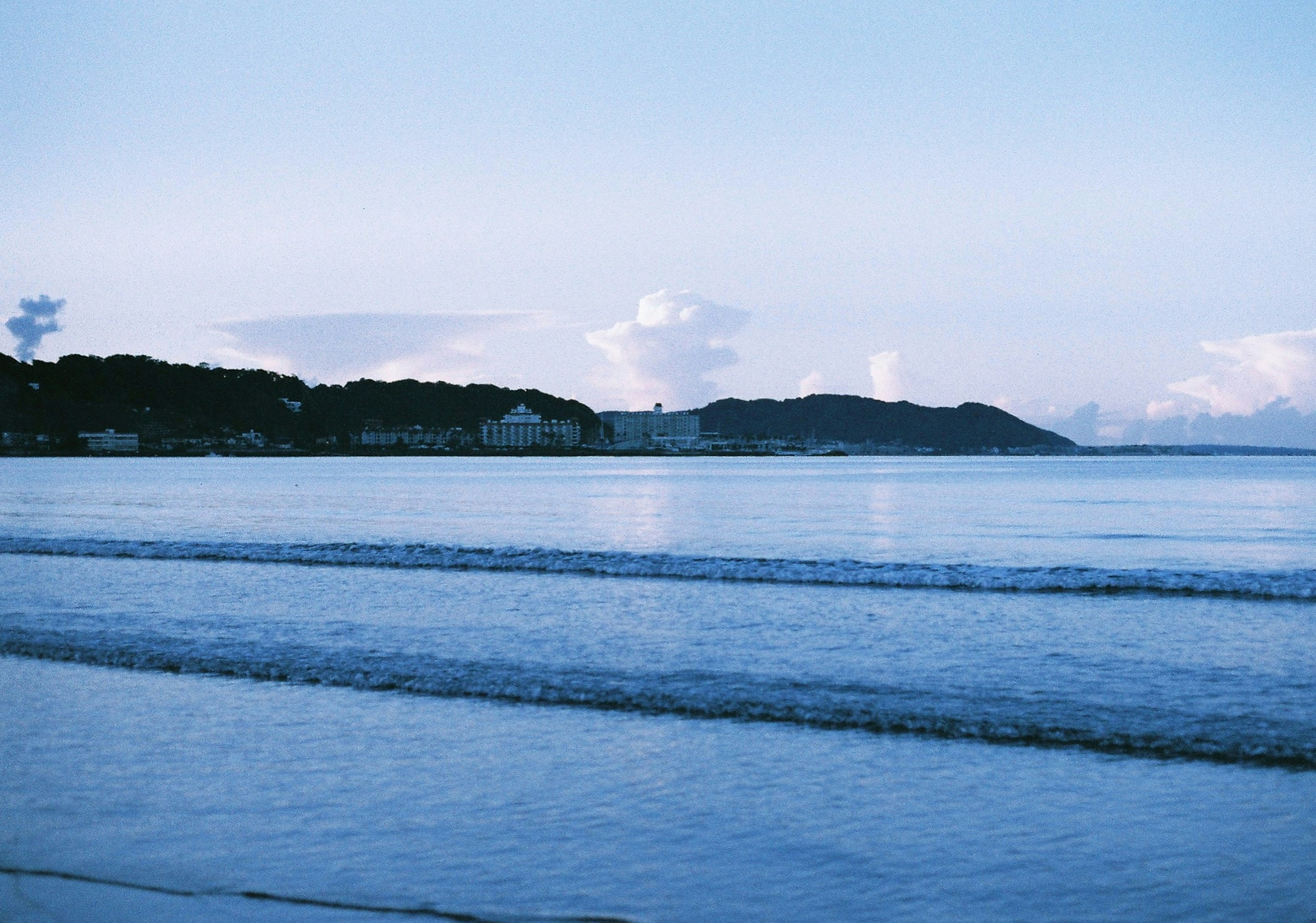 青い海と空の風景に波が寄せる