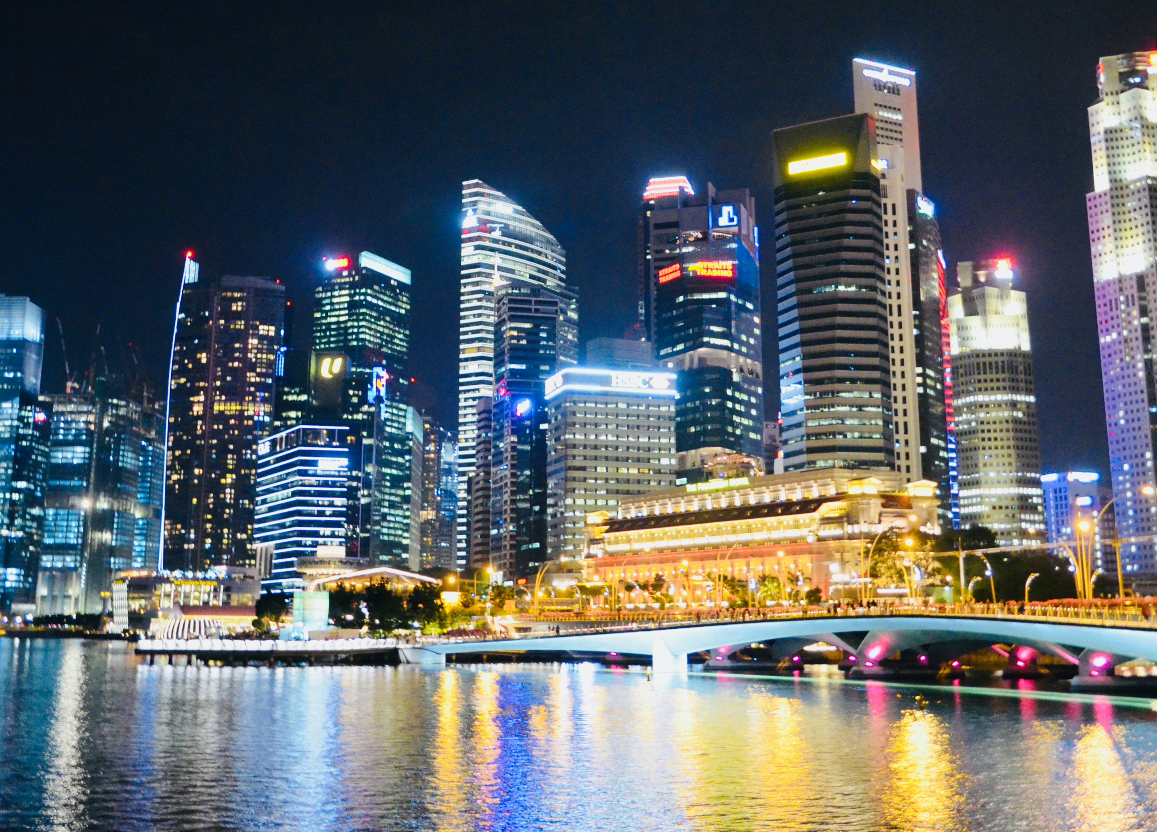 Impresionante horizonte de Singapur de noche con reflejos en el agua