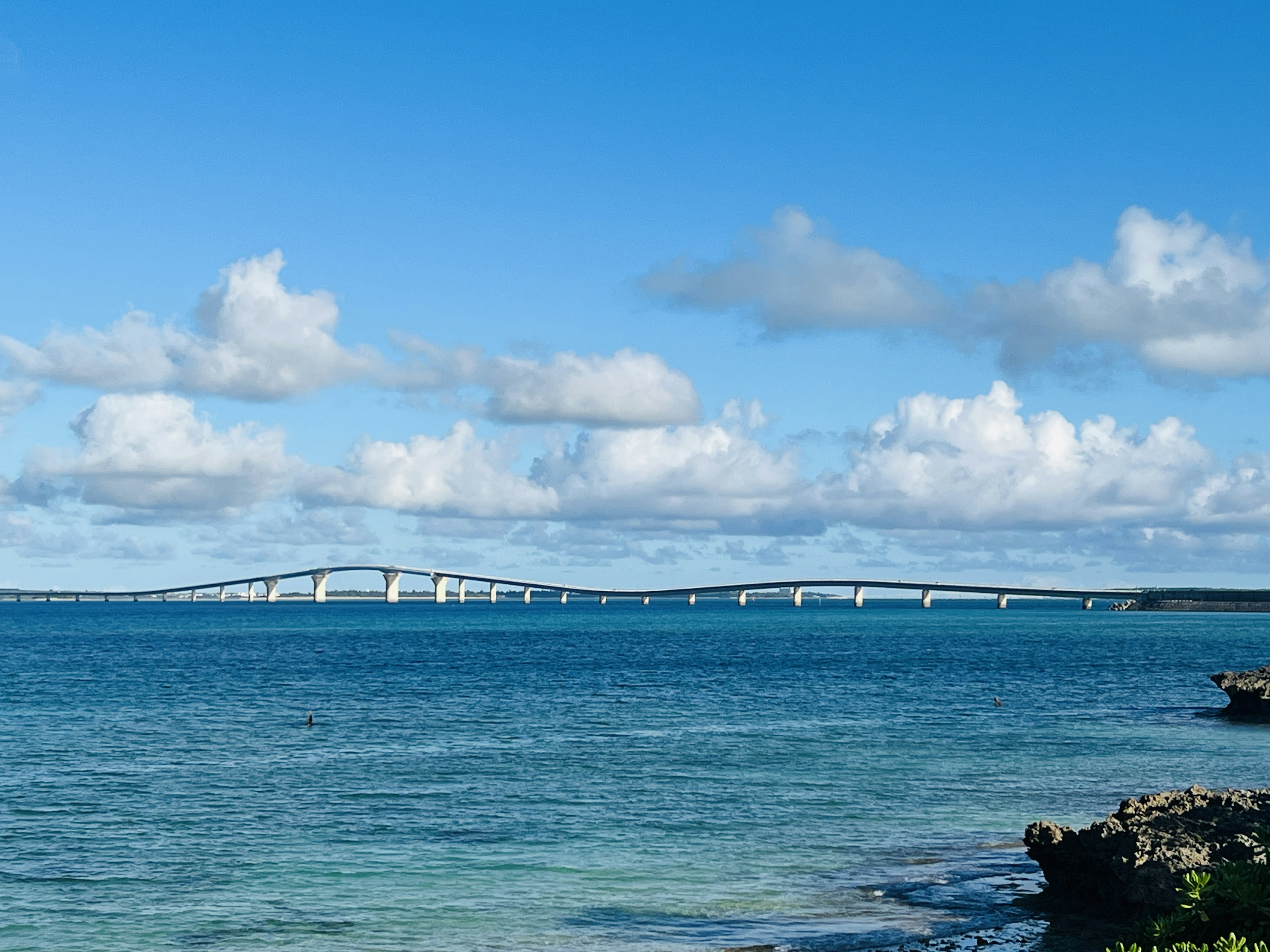 Pemandangan laut biru dengan jembatan di latar belakang