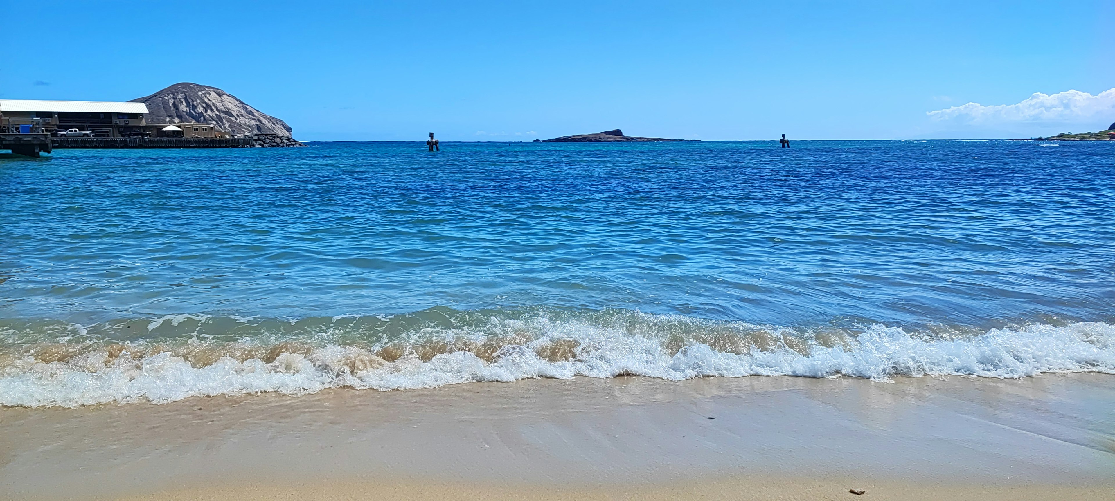 Malerscher Strandblick mit blauem Ozean und weißen Wellen