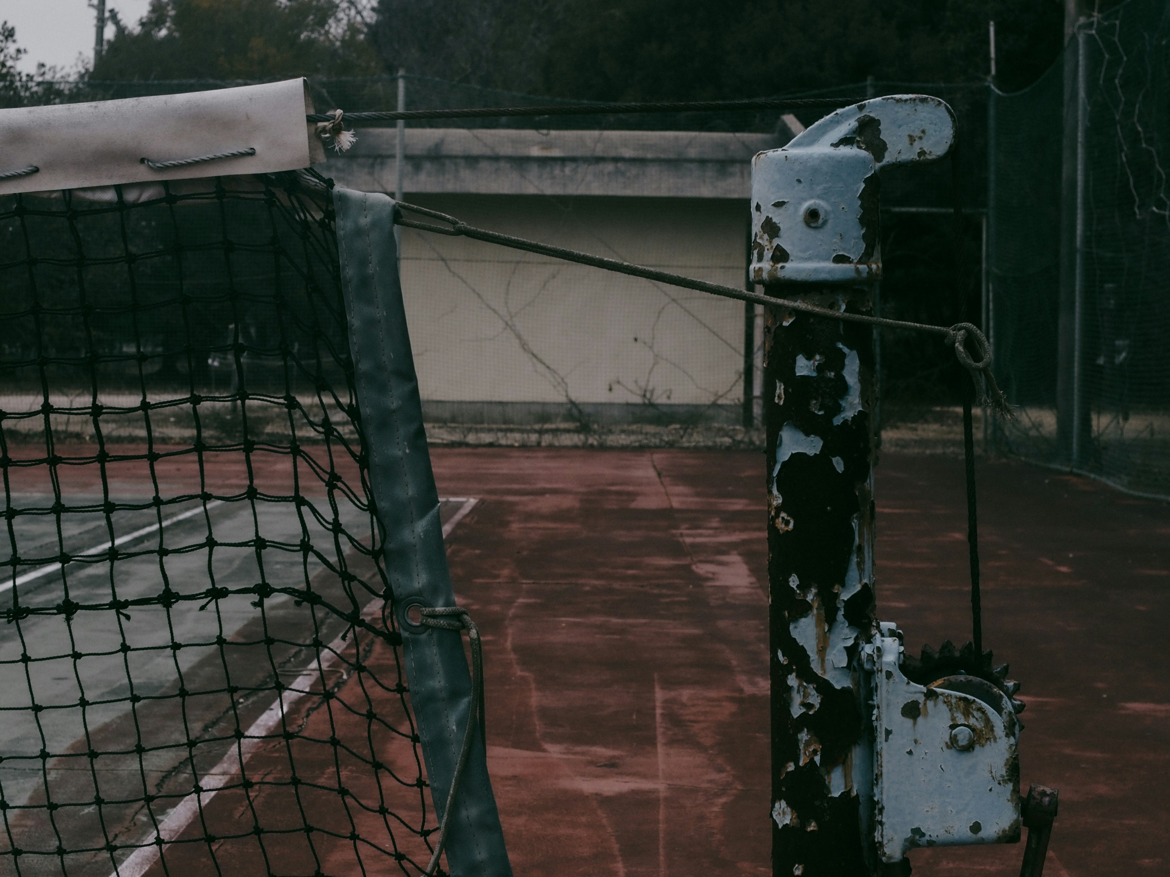 Tennis court net post with a taut net