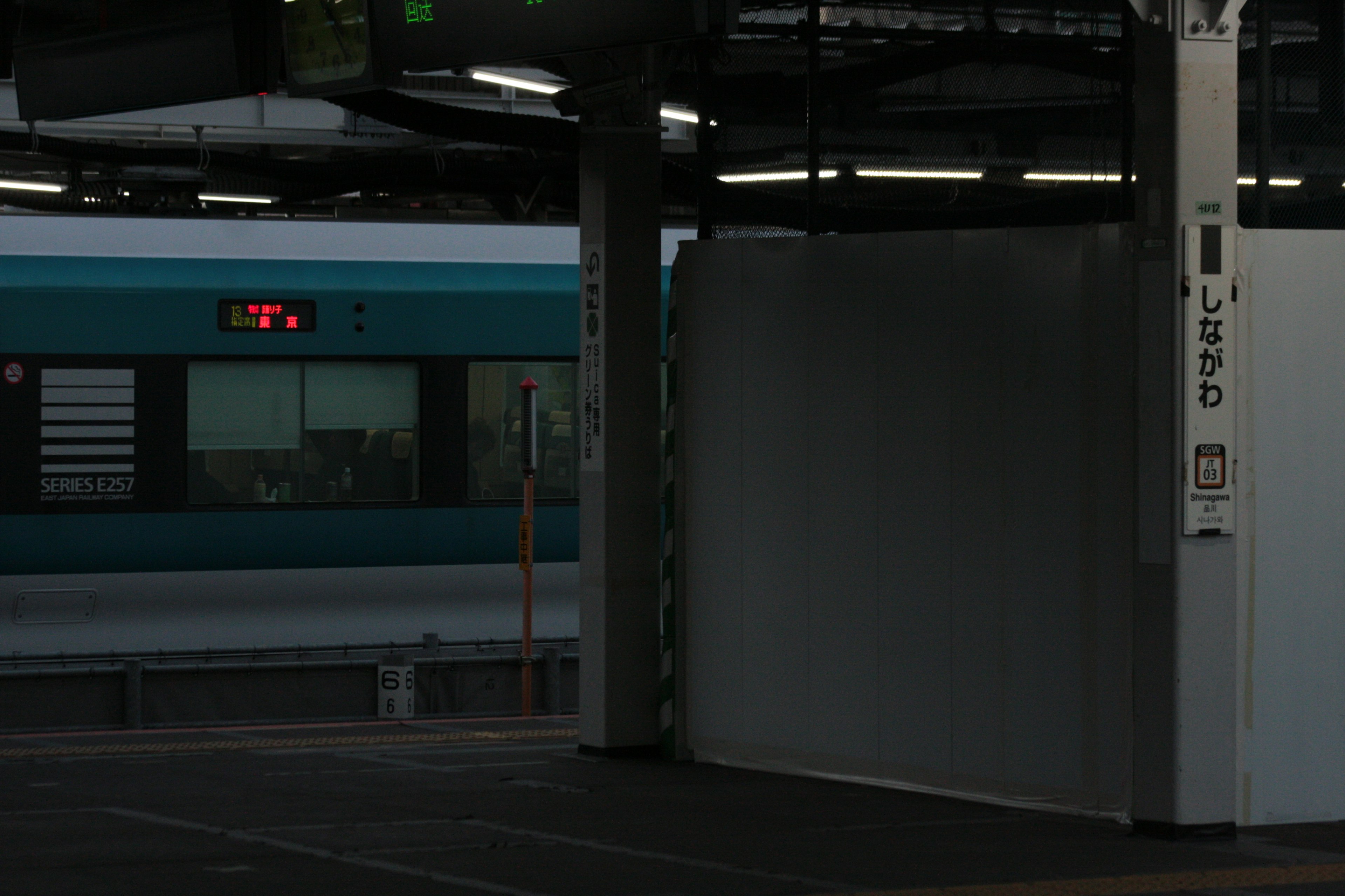 Un treno blu su una banchina con un muro bianco