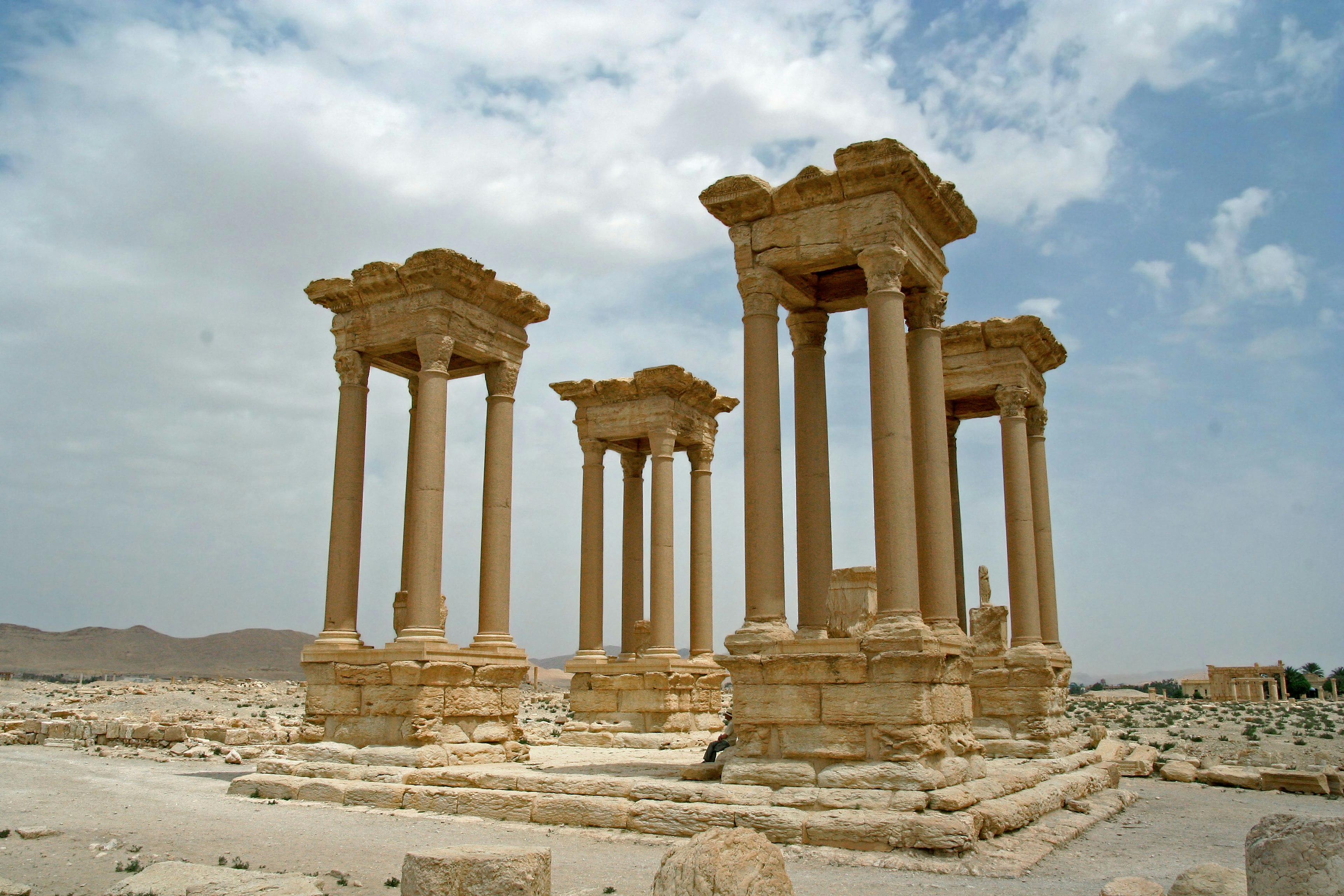 Ruinas antiguas con una columnata bajo un cielo azul