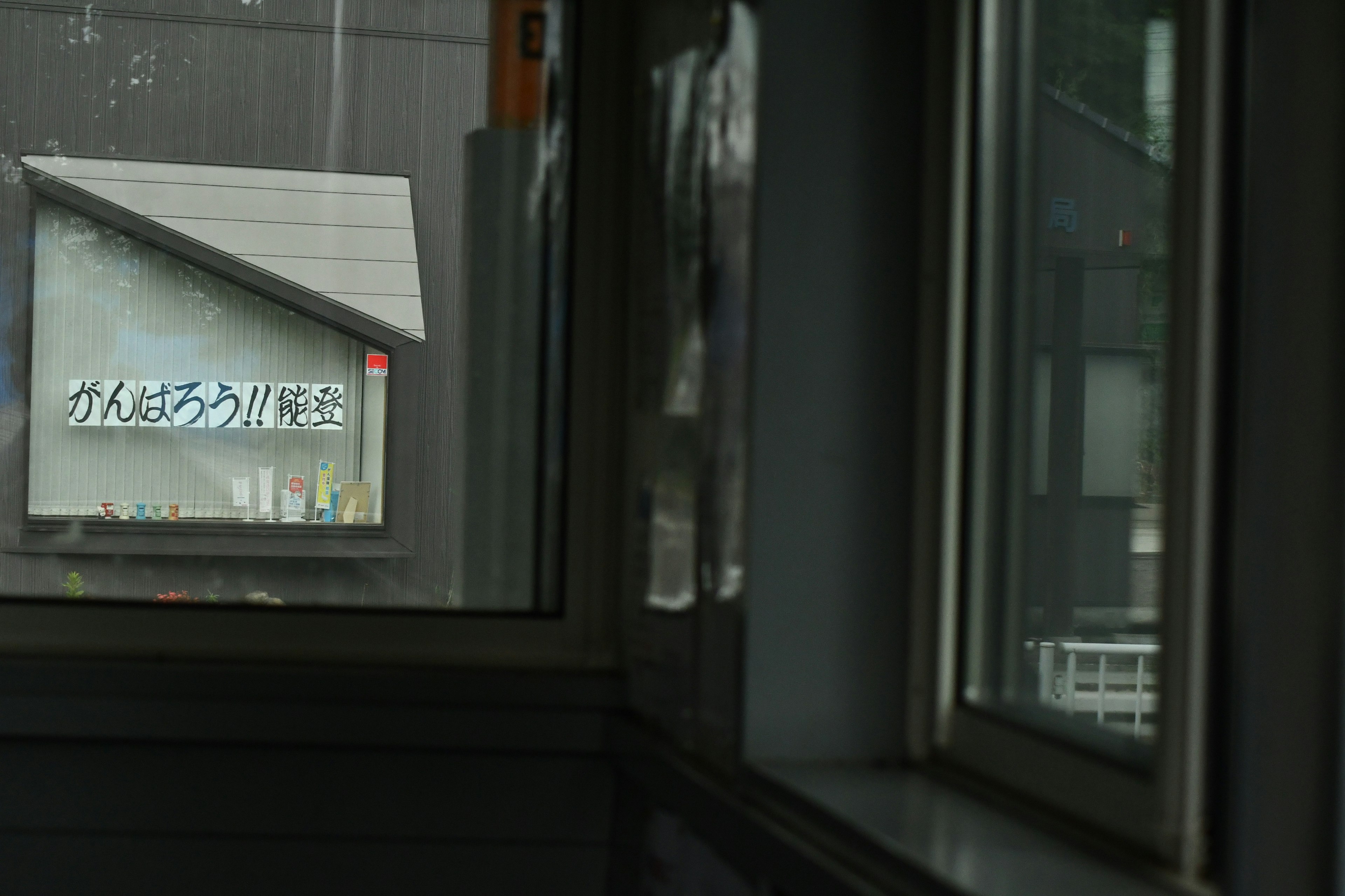 Sign visible through window with reflections