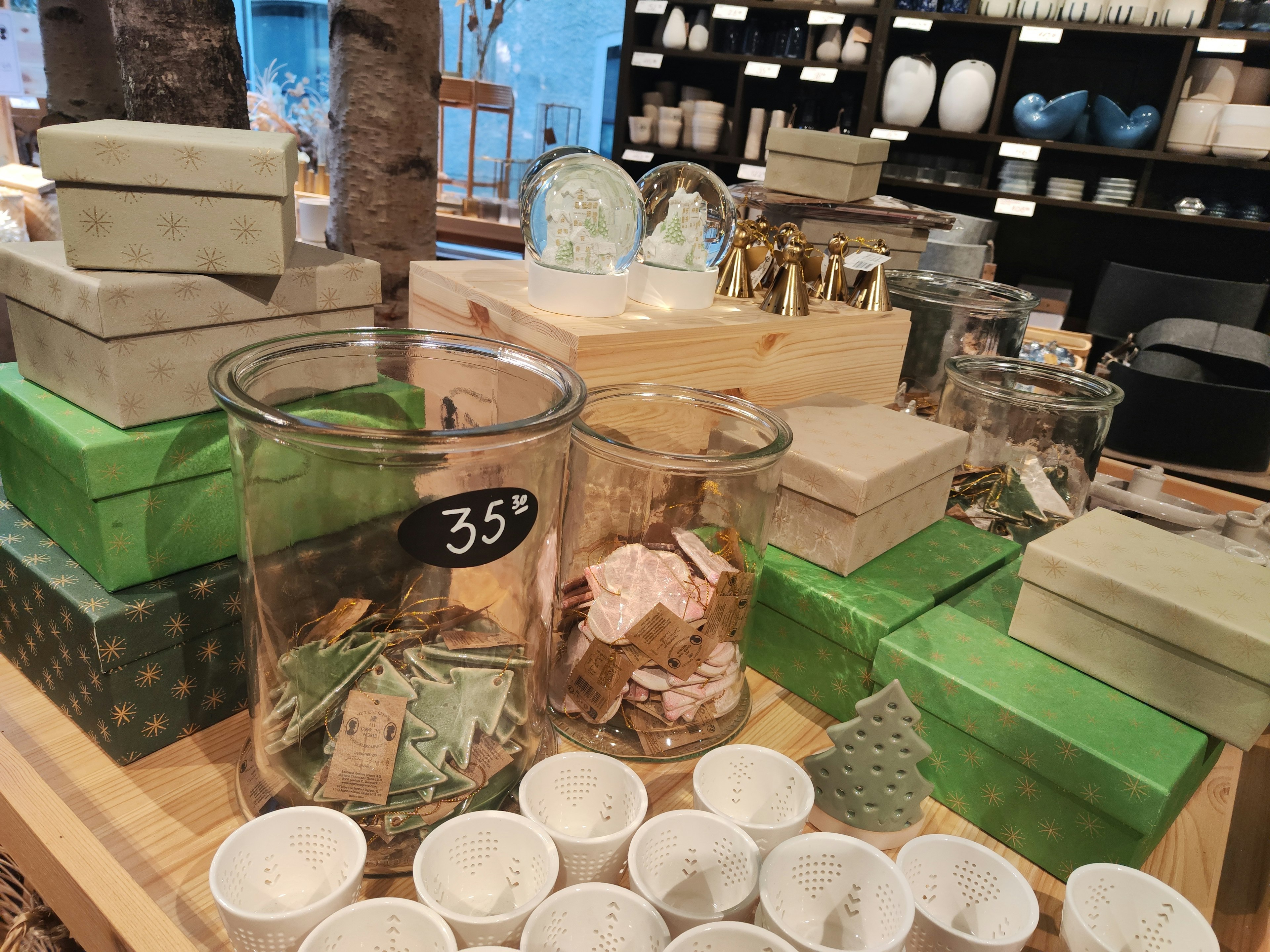 Display of green boxes and glass containers filled with items in a store