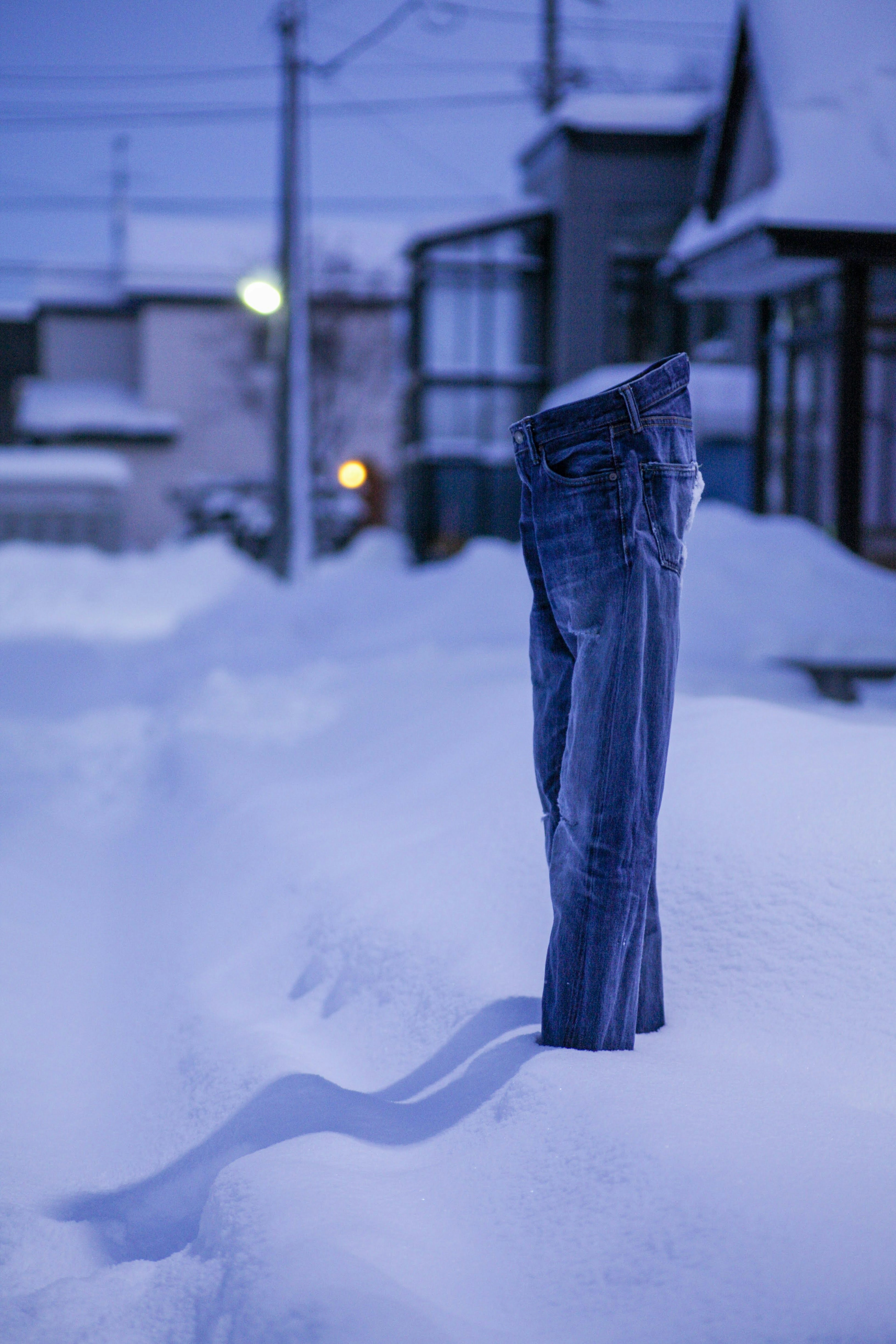 一条牛仔裤在深雪中站立，寒冷的冬夜