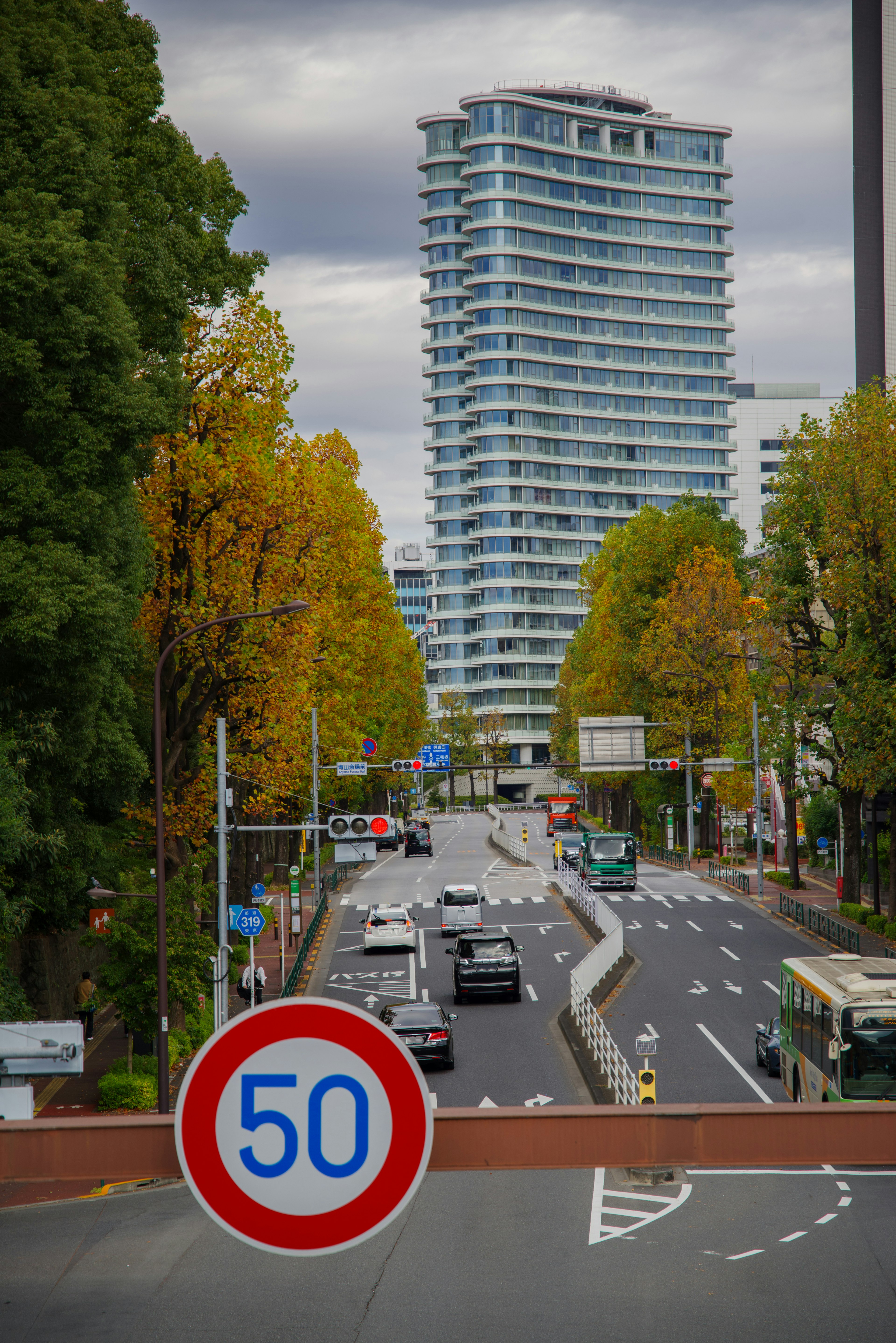 Paesaggio urbano con una strada e un cartello di limite di velocità di 50 km/h e un grattacielo moderno