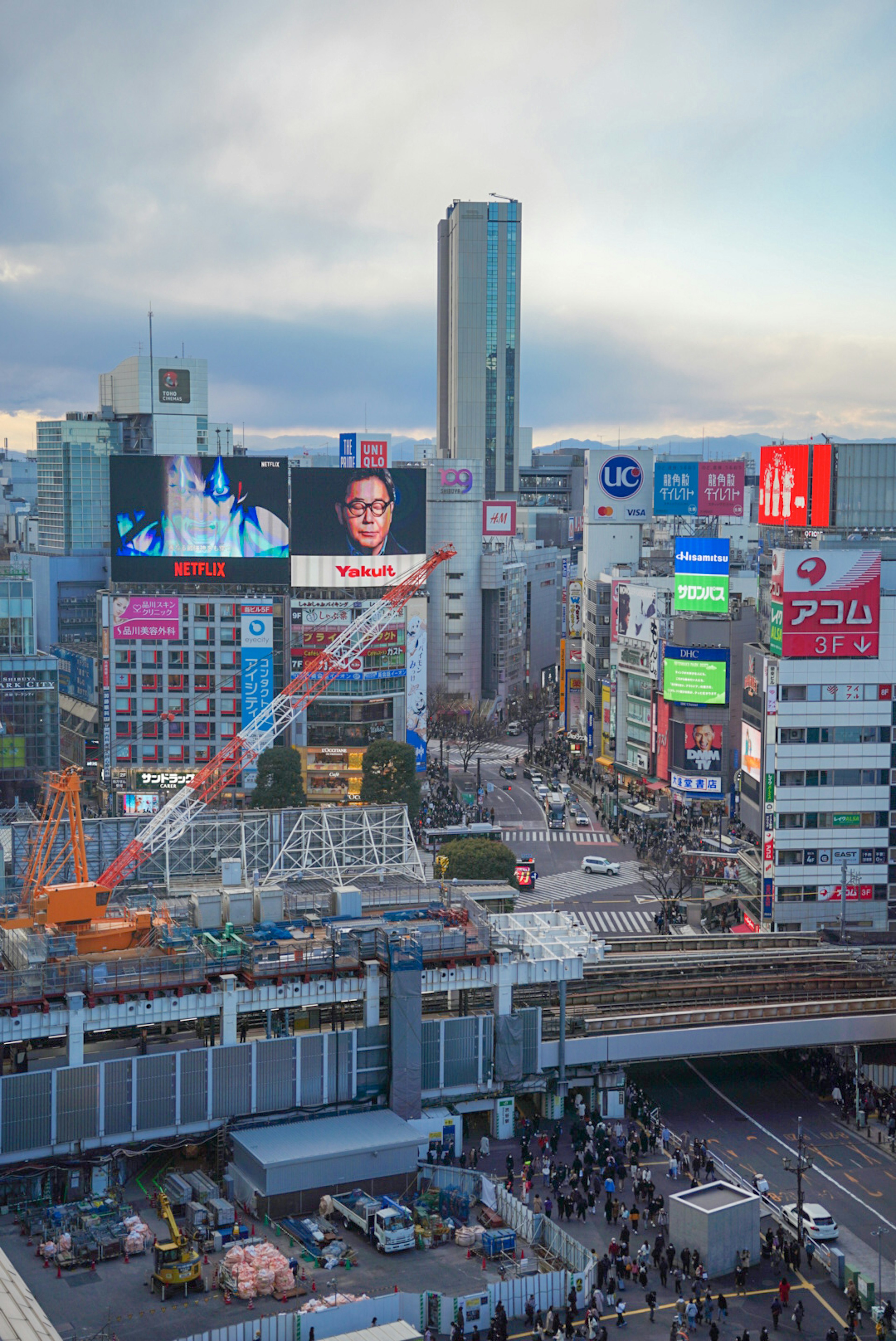 渋谷の繁華街の高層ビル群と巨大広告が並ぶ風景