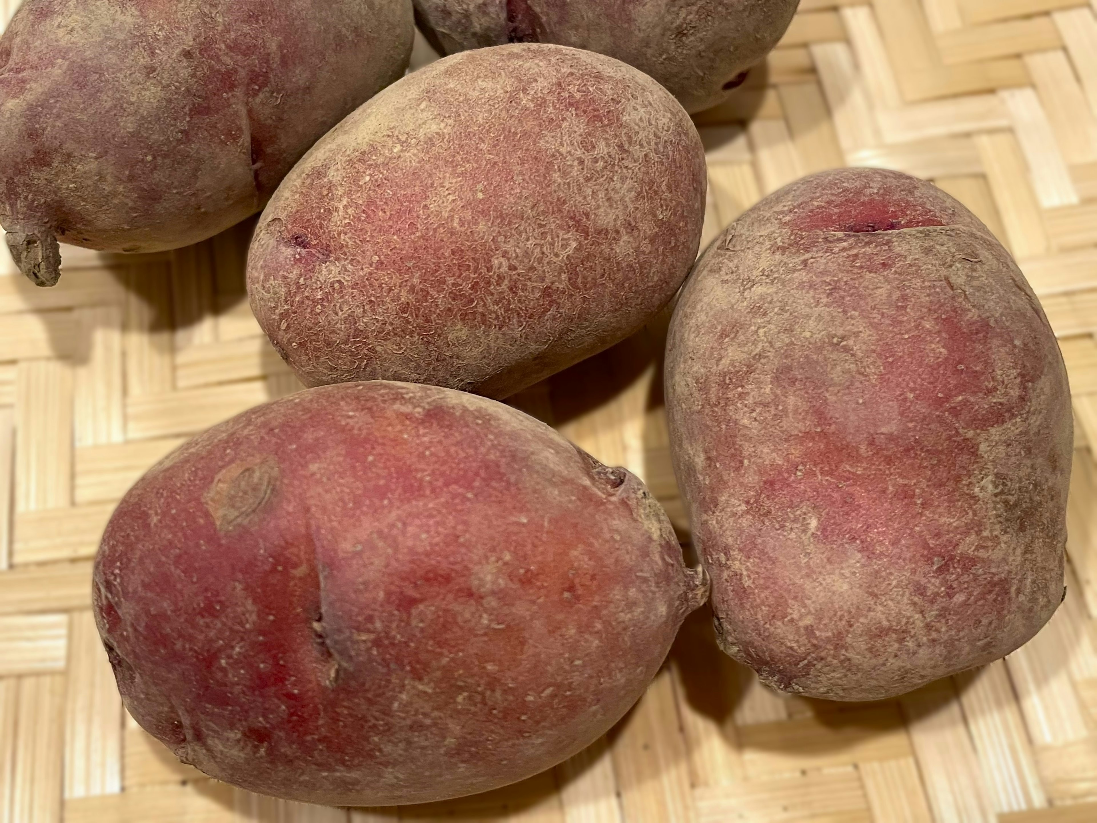 Pommes de terre à peau rouge disposées sur un panier tressé