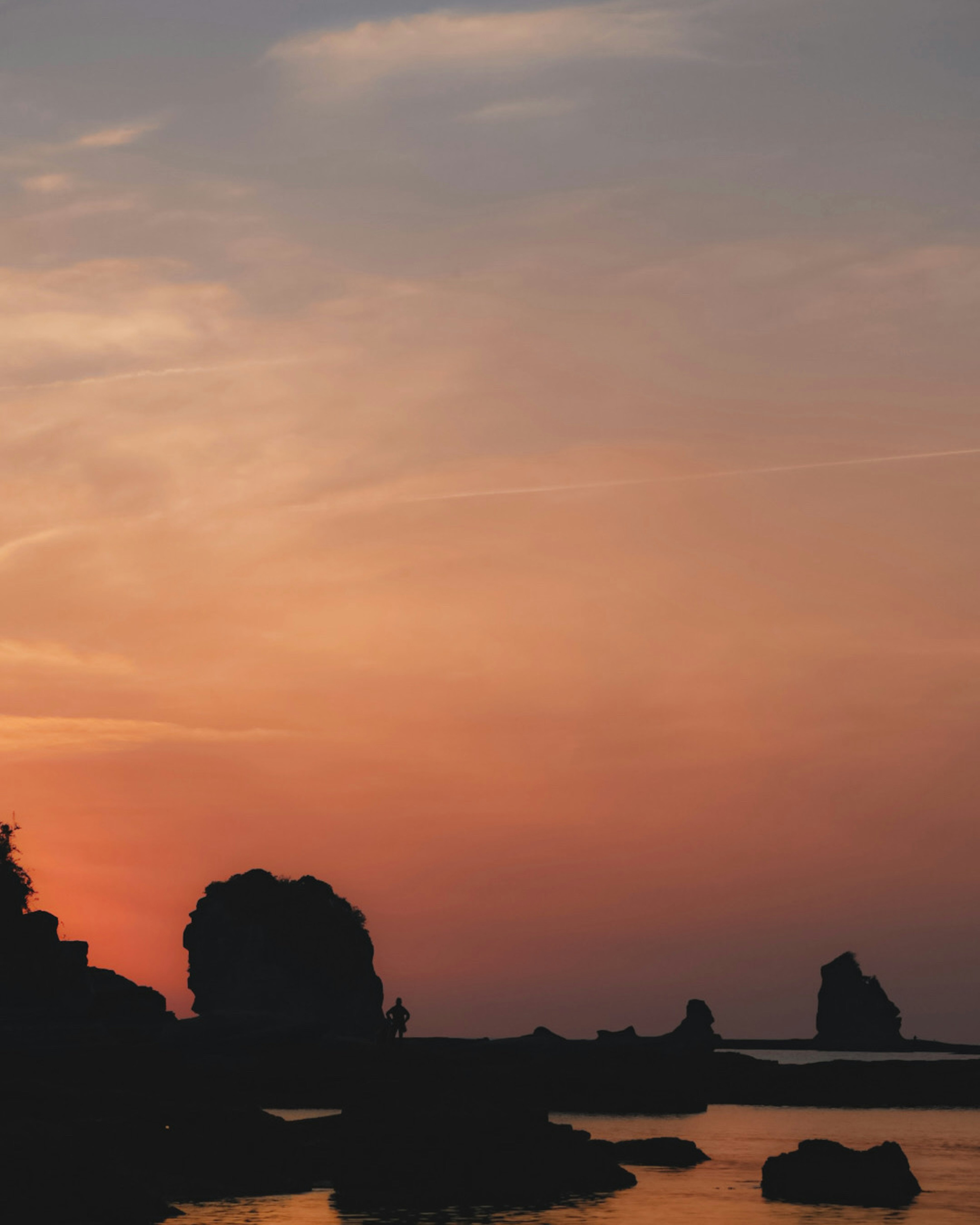 Tranquil landscape with a sunset sky and silhouetted rocks