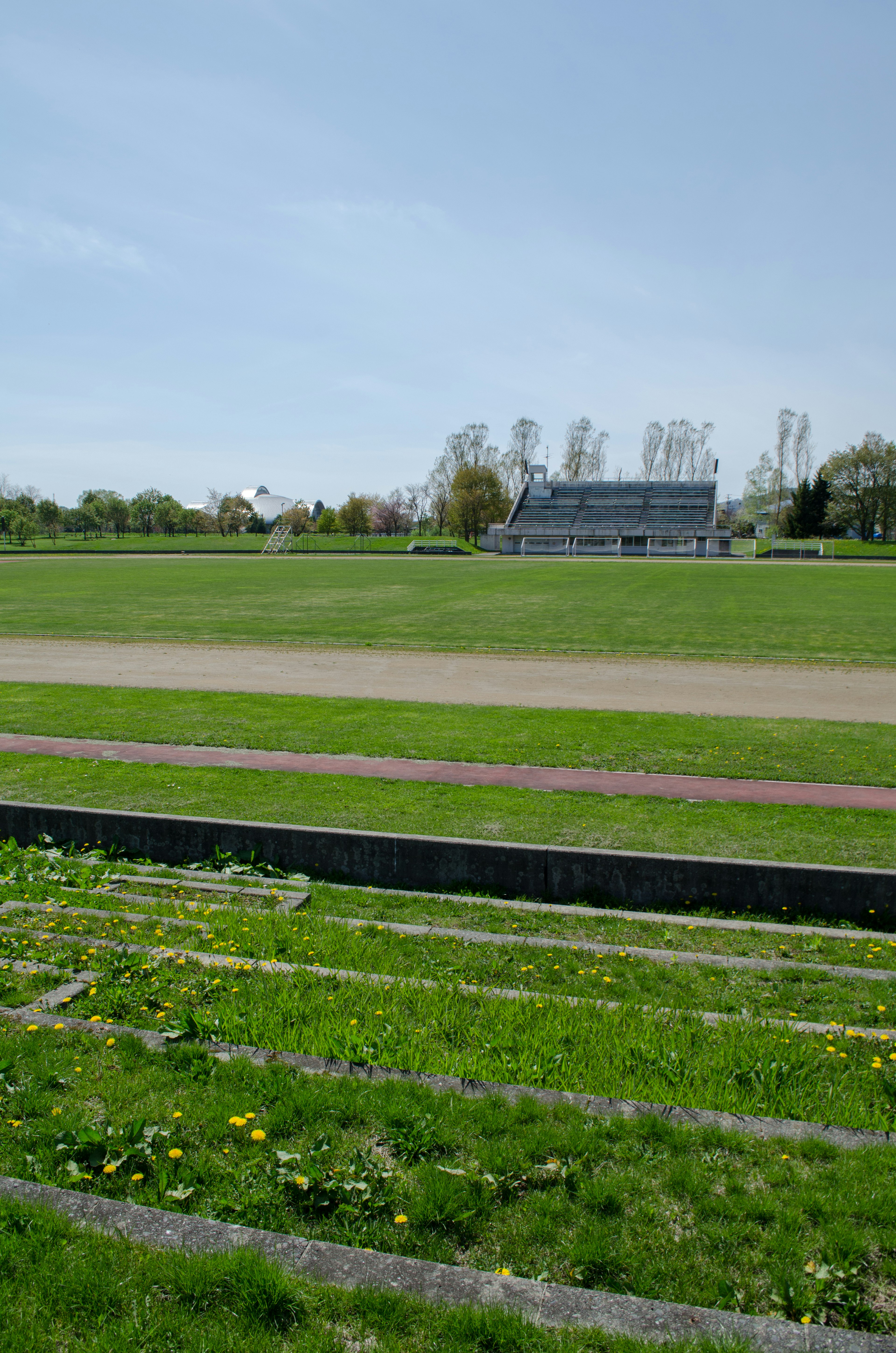 Champ vert spacieux avec une tribune visible à l'arrière-plan