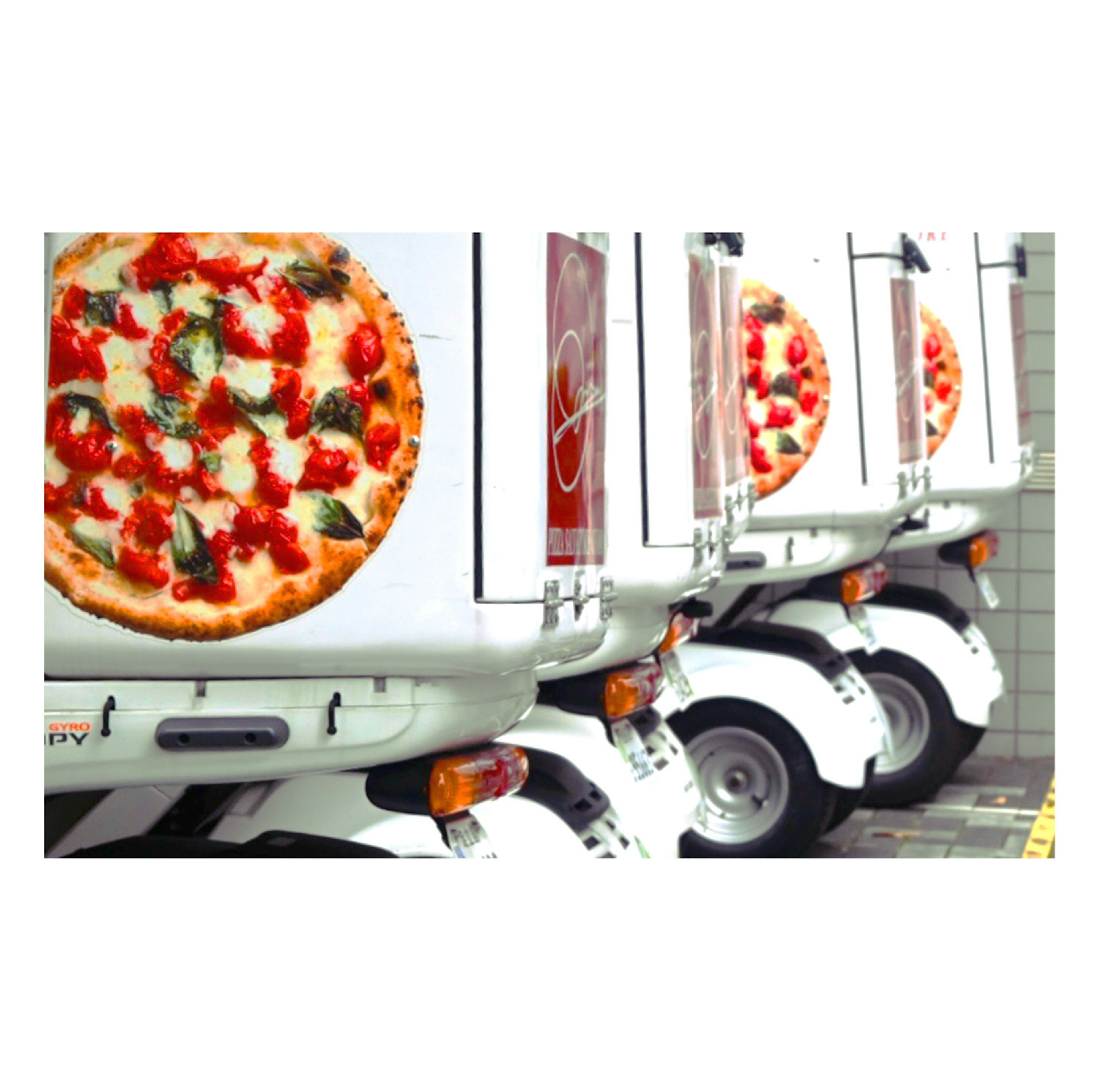 Delivery trucks featuring pizza advertisements lined up