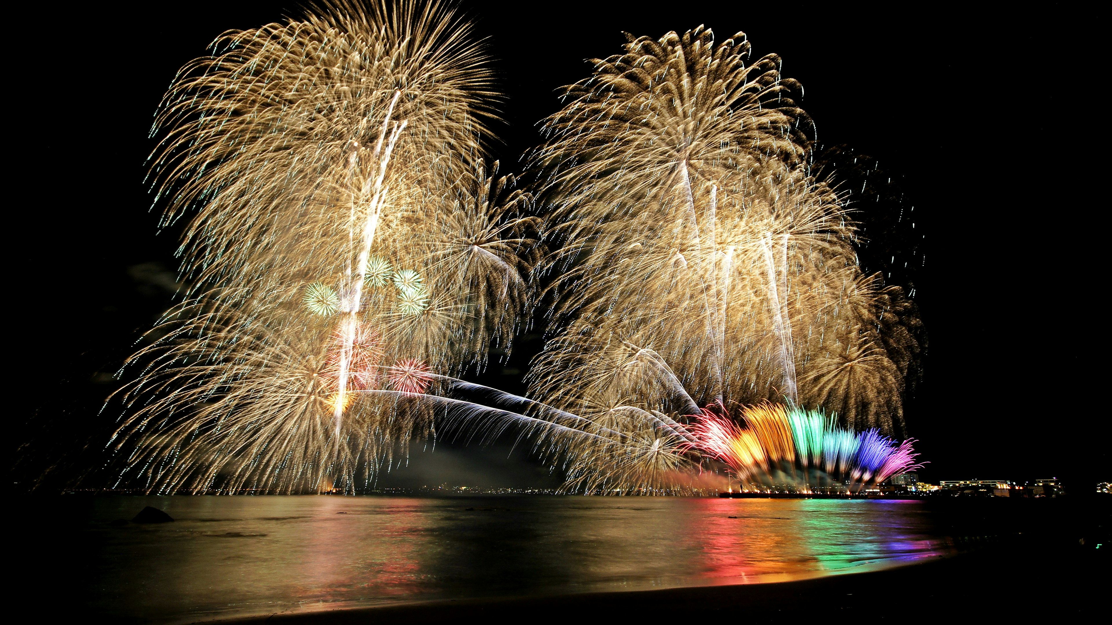 Spettacolo di fuochi d'artificio colorati sull'acqua di notte