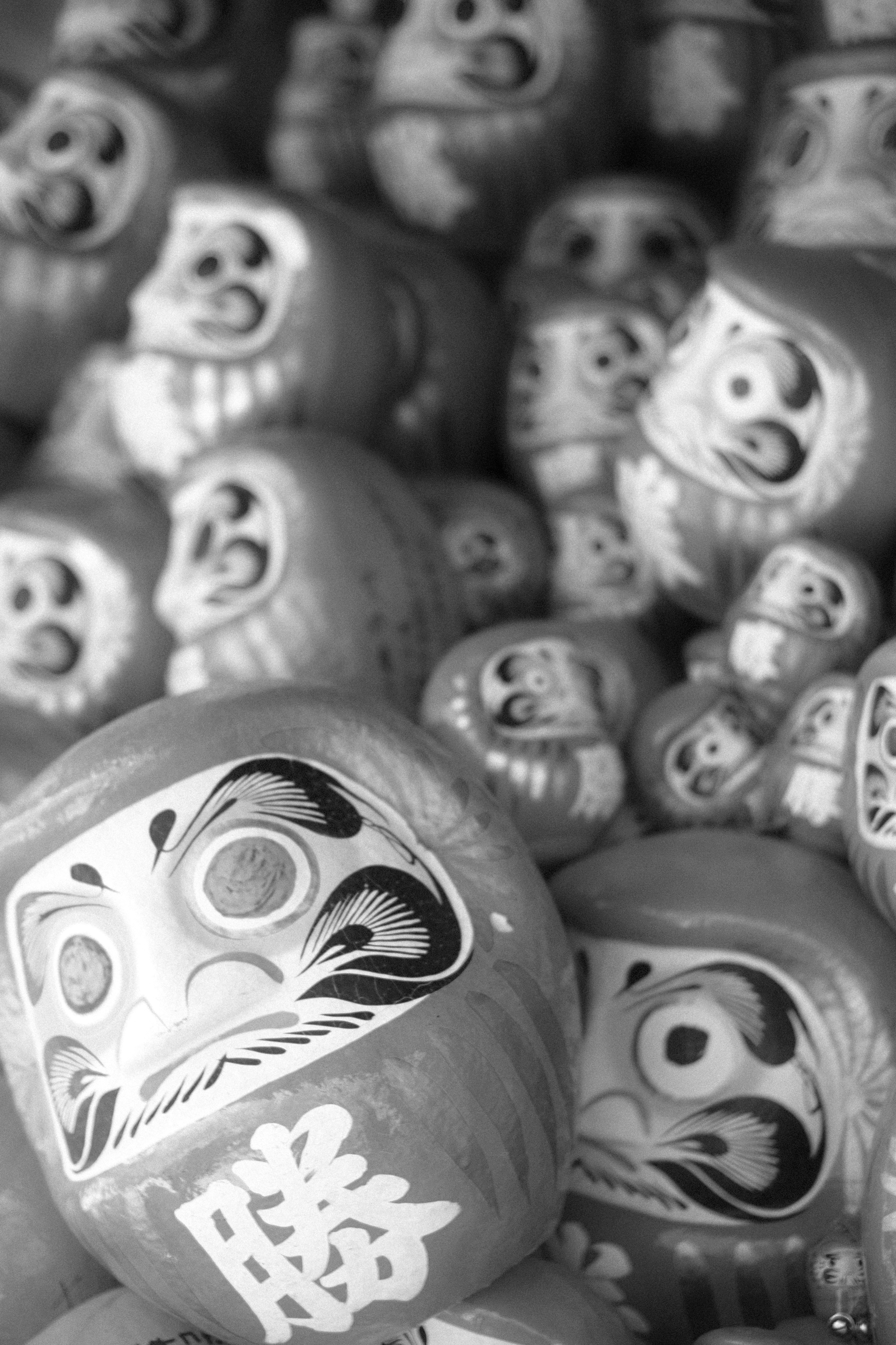 A cluster of Daruma dolls in black and white