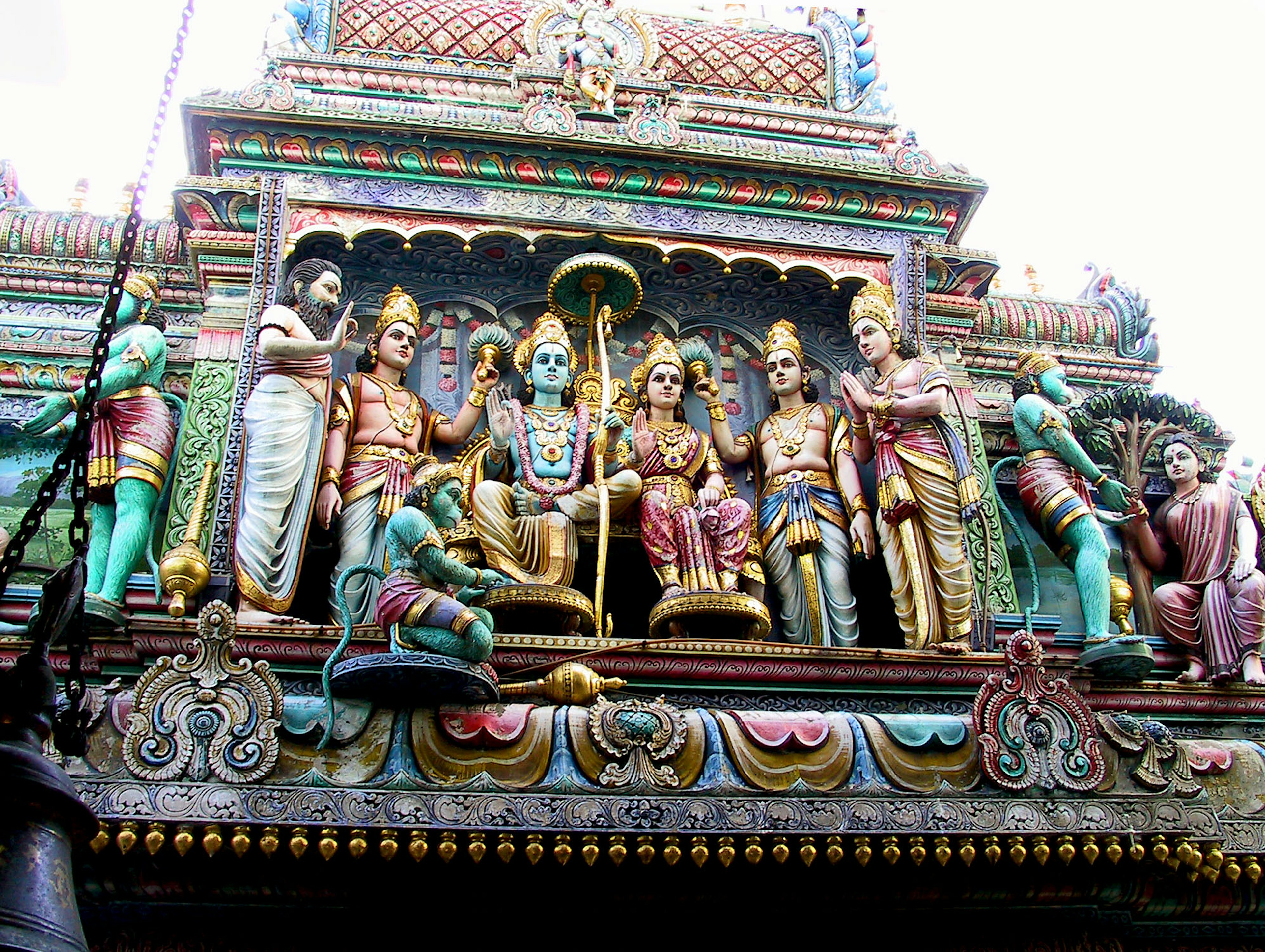 Esculturas coloridas de deidades sentadas en la fachada de un templo